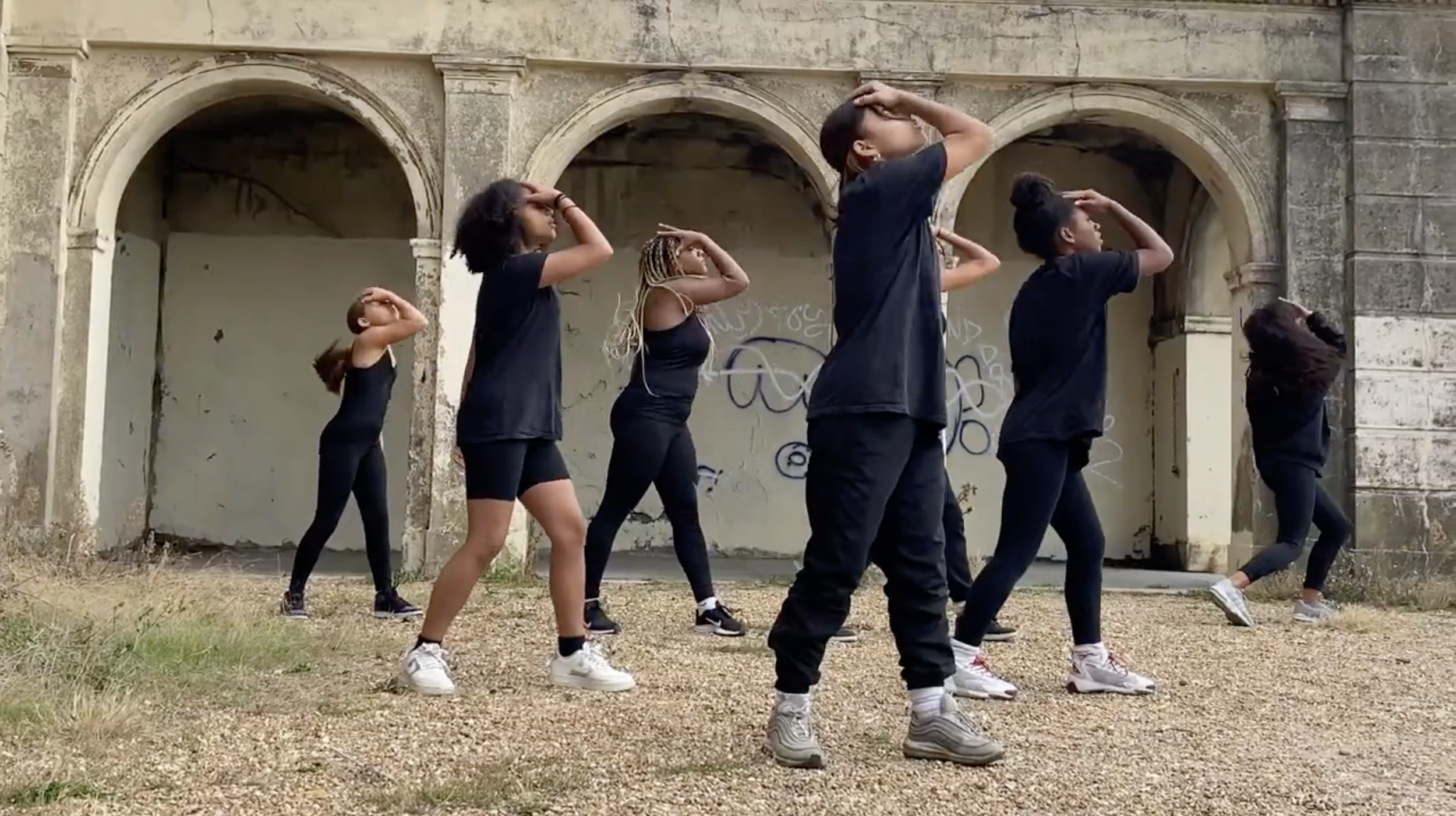 Dancers dressed in black outside