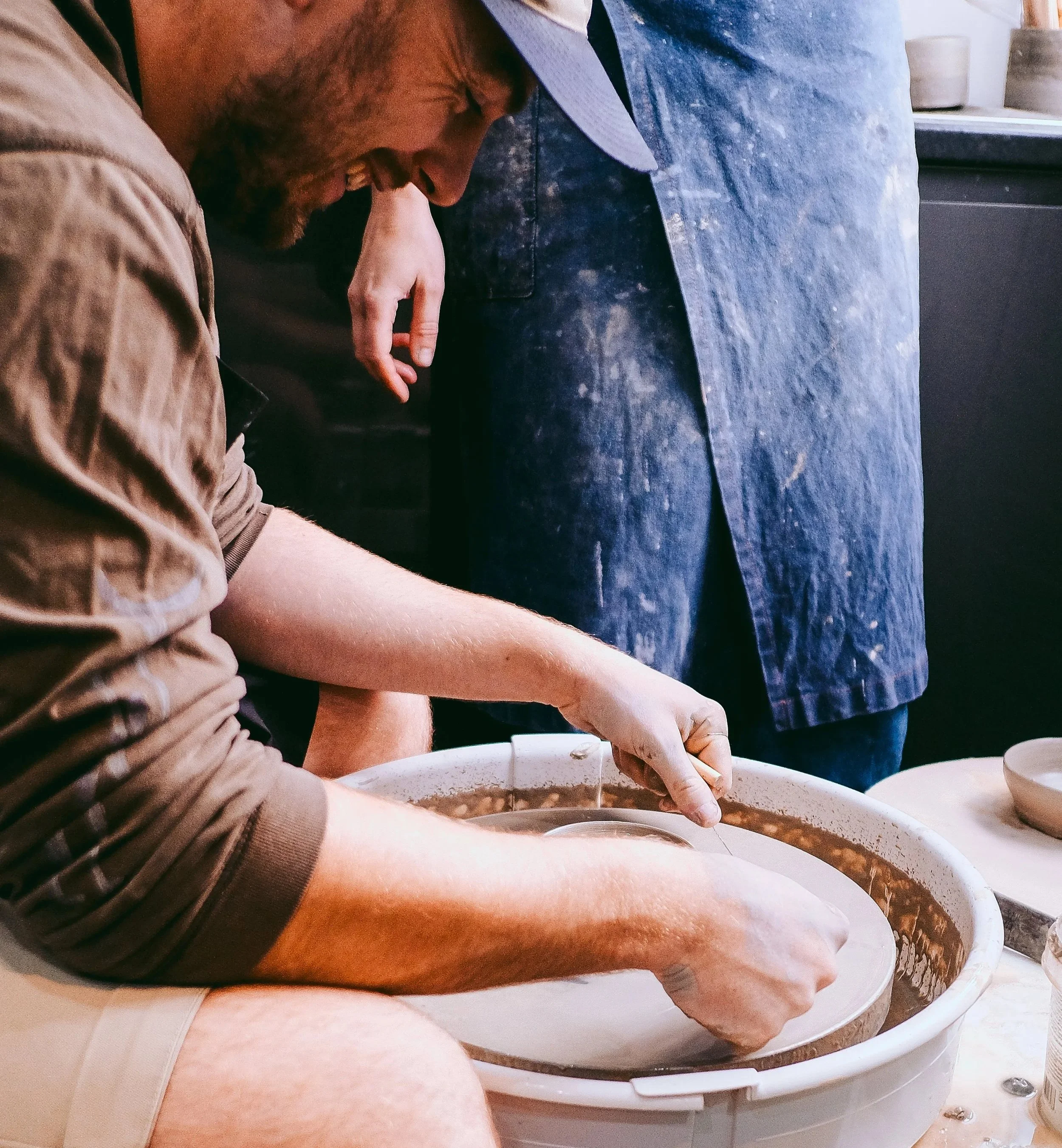Pottery classes in Macclesfield, Emma teaching a beginneer potter on the pottery wheel