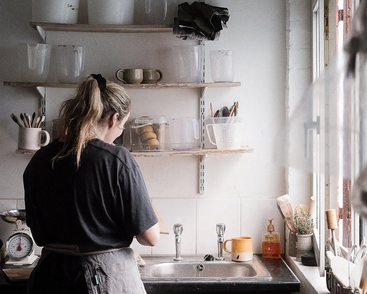 Emma cleaning in her pottery studio after a pottery class
