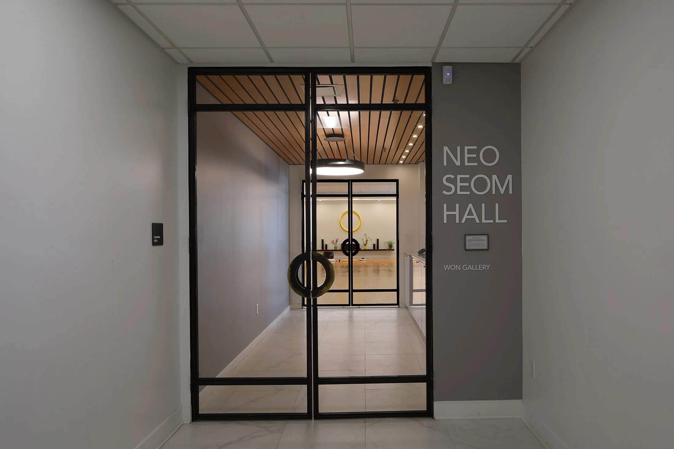 Entrance to NEO SEOM HALL with glass doors, interior decor, and signage.