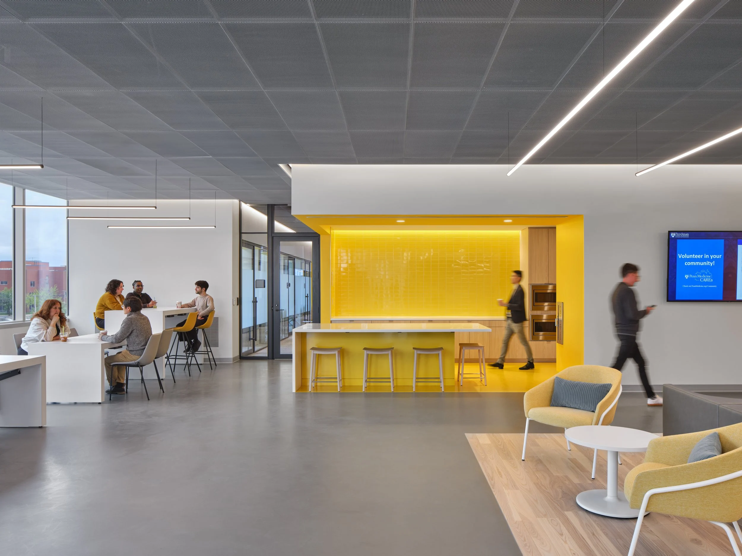 Office space with modern kitchen and bar with open concept seating, lounge, and work spaces. 