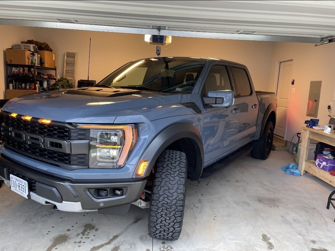 A silver pickup truck parked inside a garage.