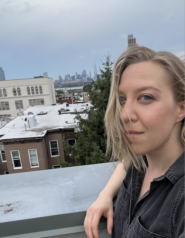 Image of Mae Sevick, founder of Artemetrics, in a Brooklyn building overlooking the Manhattan skyline in New York City.