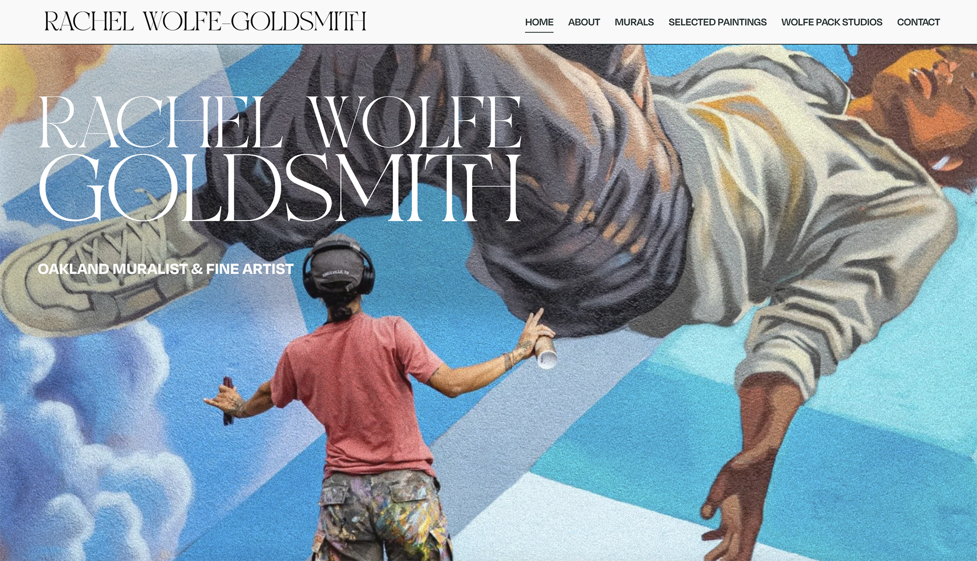 A muralist painting a large mural on a wall, depicting a person lying down and reaching upwards. The mural features vibrant colors and realistic details.