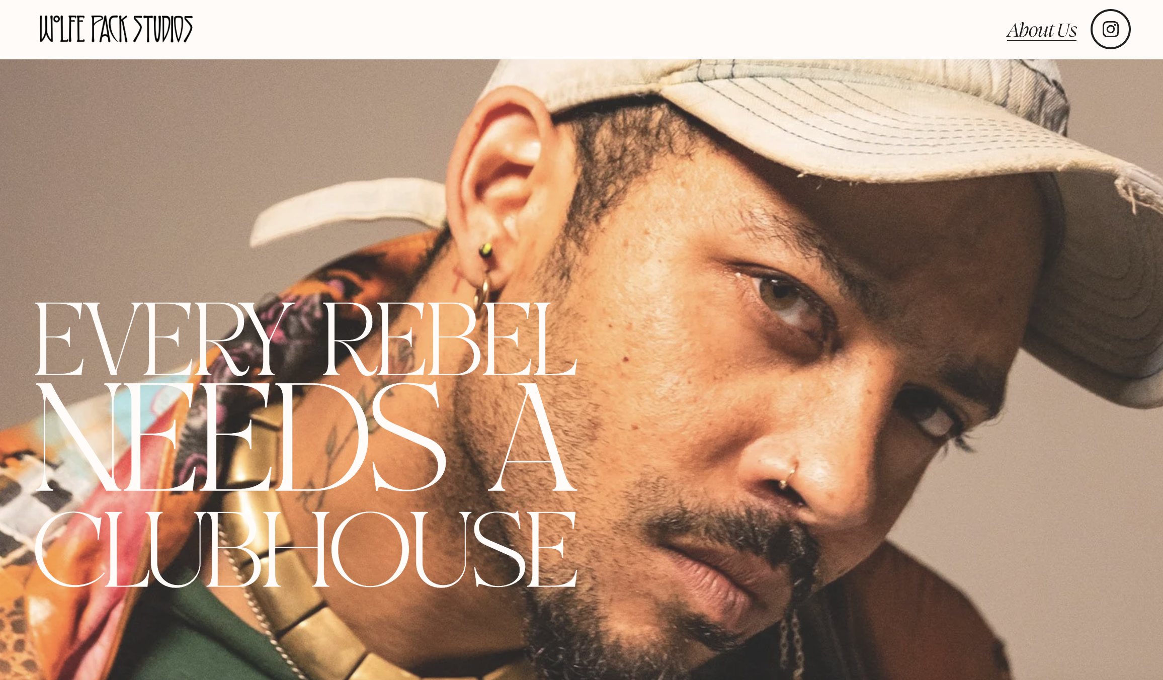 Close-up of a man with a tan hat, multiple earrings, a nose ring, and a colorful shirt, with text overlay: "Every rebel needs a clubhouse."