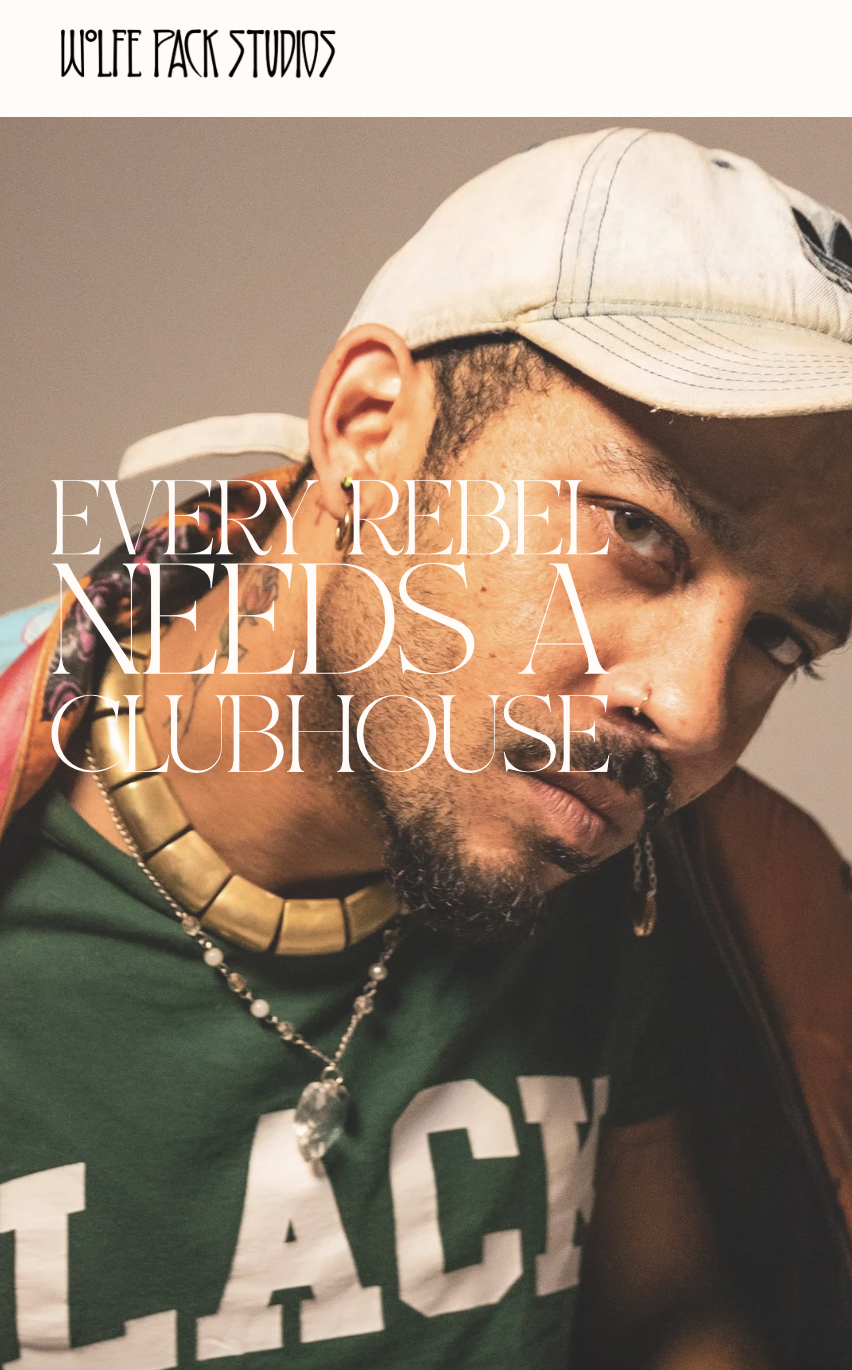 Close-up of a person wearing a beige cap, green shirt with white text, layered necklaces, and earrings, with overlay text reading 'Every rebel needs a clubhouse.'