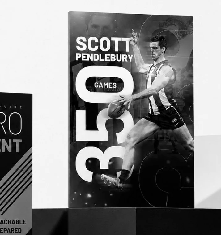 Black and white poster of Scott Pendlebury playing football, with large text "Scott Pendlebury GAMES" and a logo in the background.