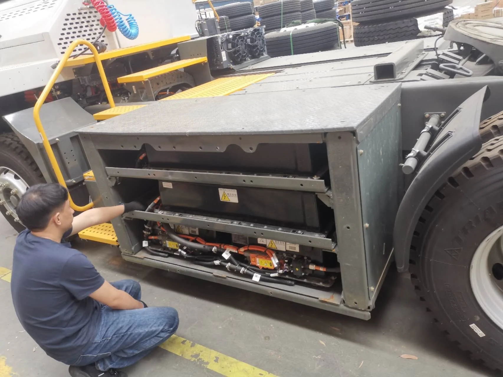 EV battery specialist inspecting the battery compartment of an electric truck in our customer's maintenance facility.