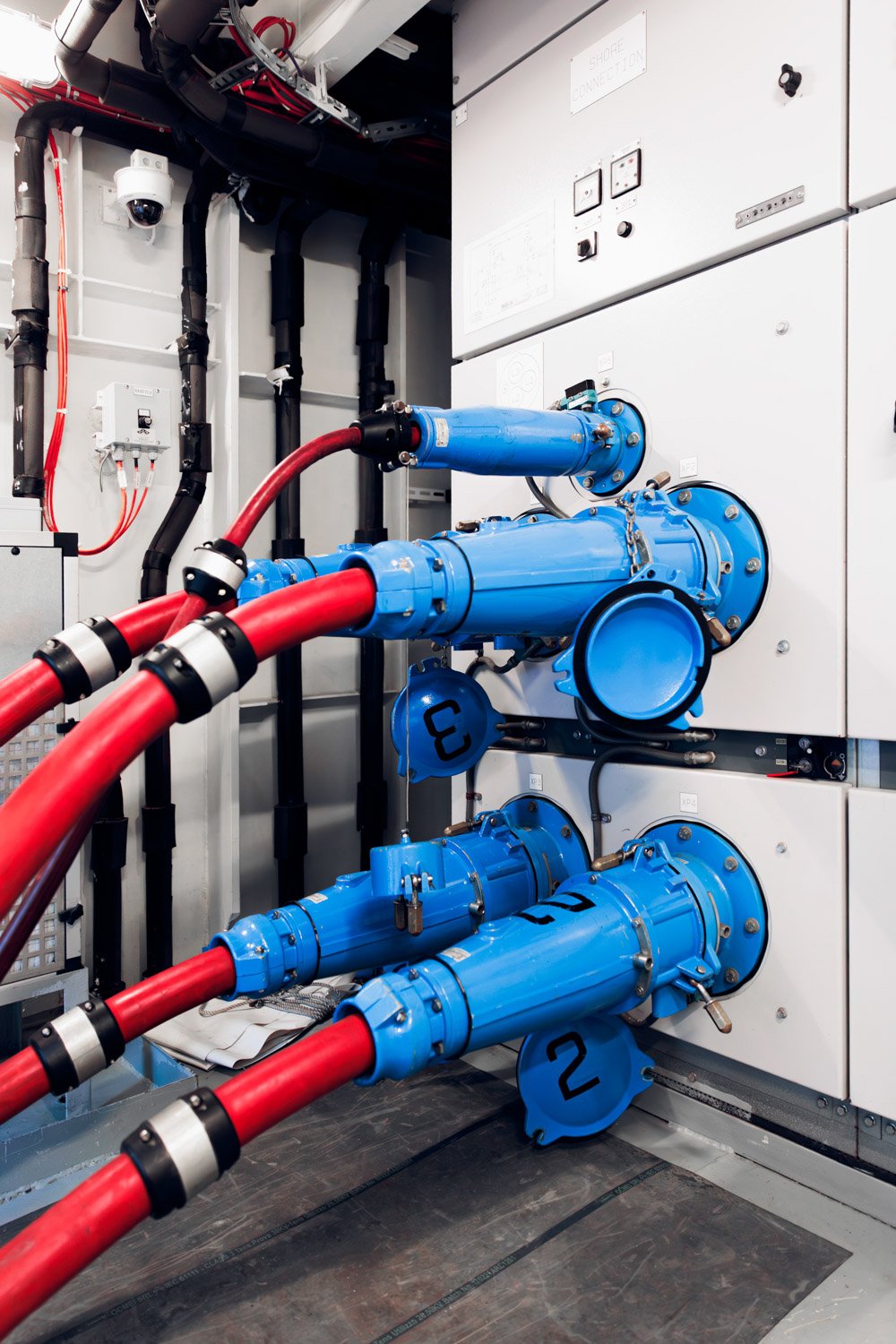 Industrielle vannrør med blå ventiler og rørsystem i et maskinrom.
