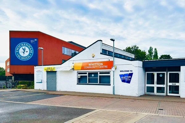 Exterior view of Whitton Community Centre with sign and parking area