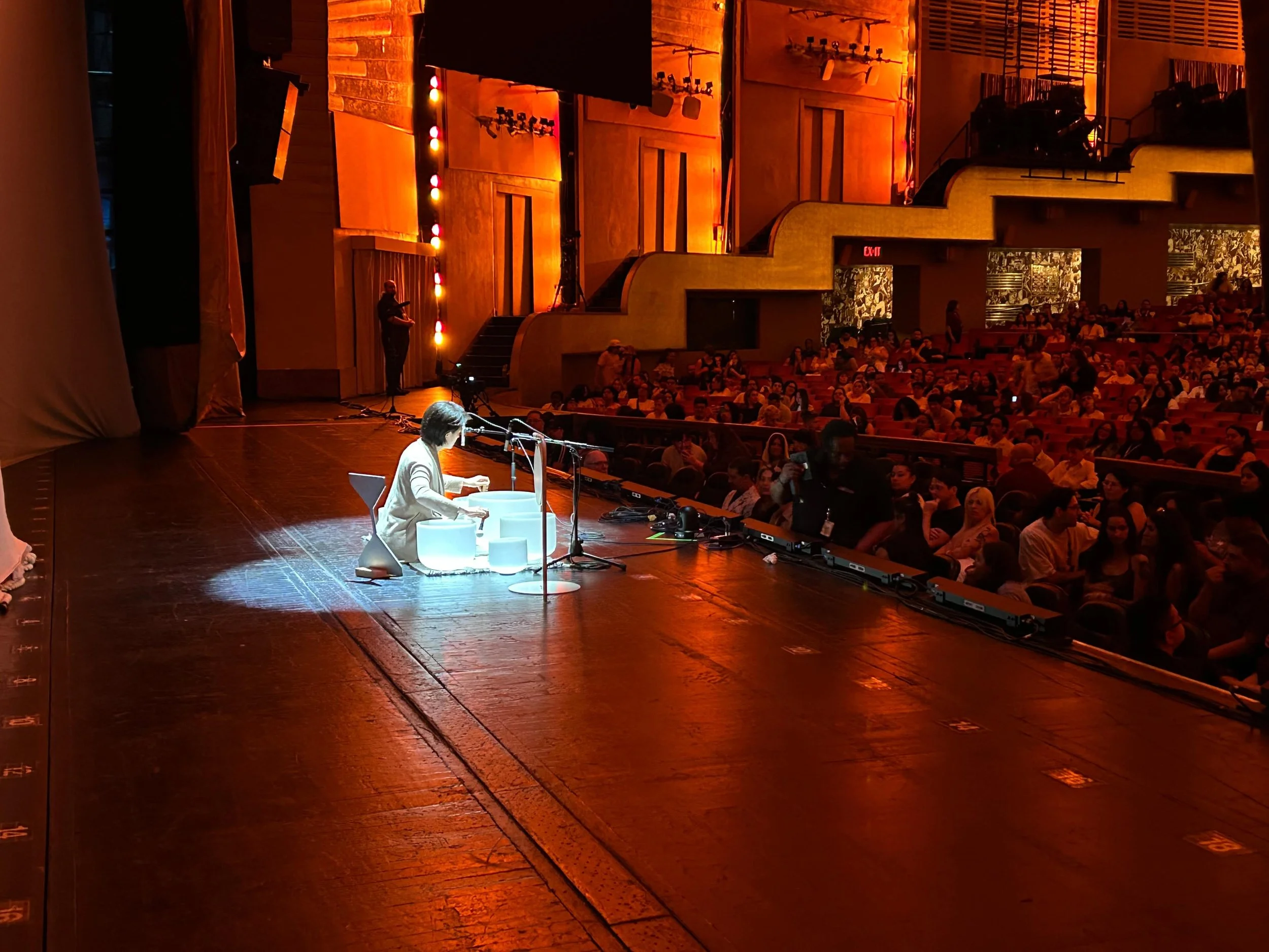 Natalie Chan performing crystal sound bowls at her station on stage at Radio City Music Hall, opening for CA7RIEL & Paco Amoroso — Soundawn.