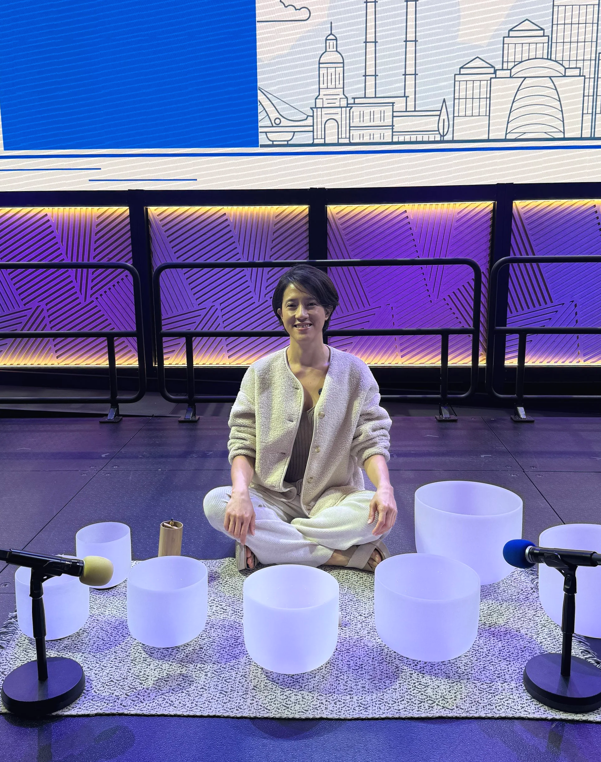 Natalie Chan seated with crystal bowls onstage for a Google summit wellness session — Soundawn NYC.