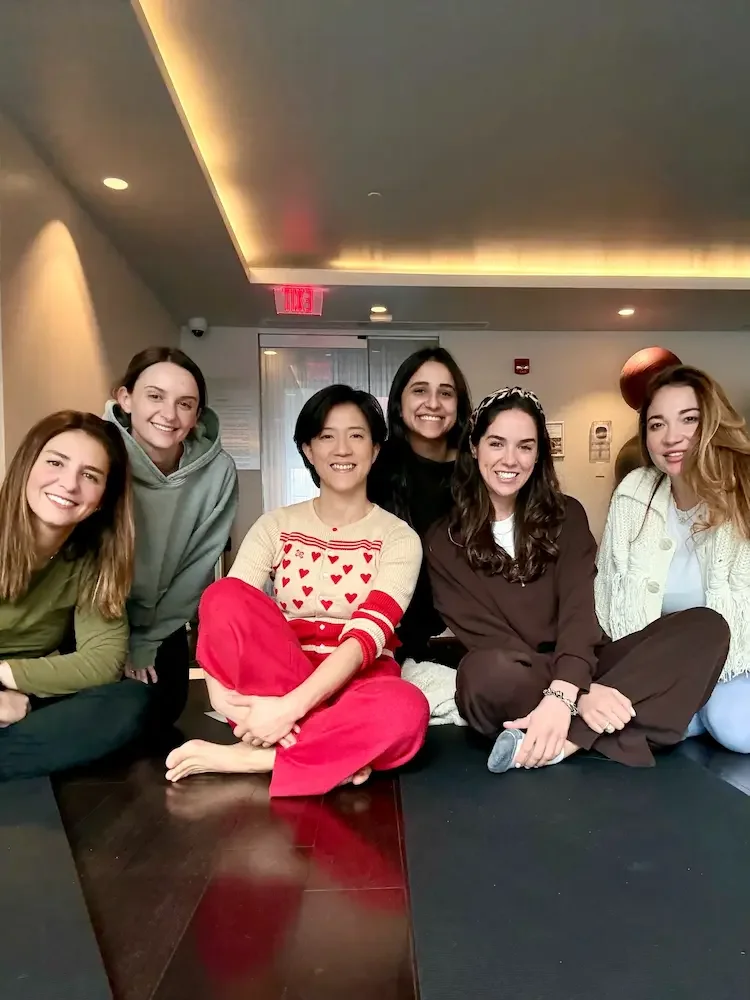 Group of friends gathered and smiling at a birthday sound bath celebration with Soundawn in Brooklyn.