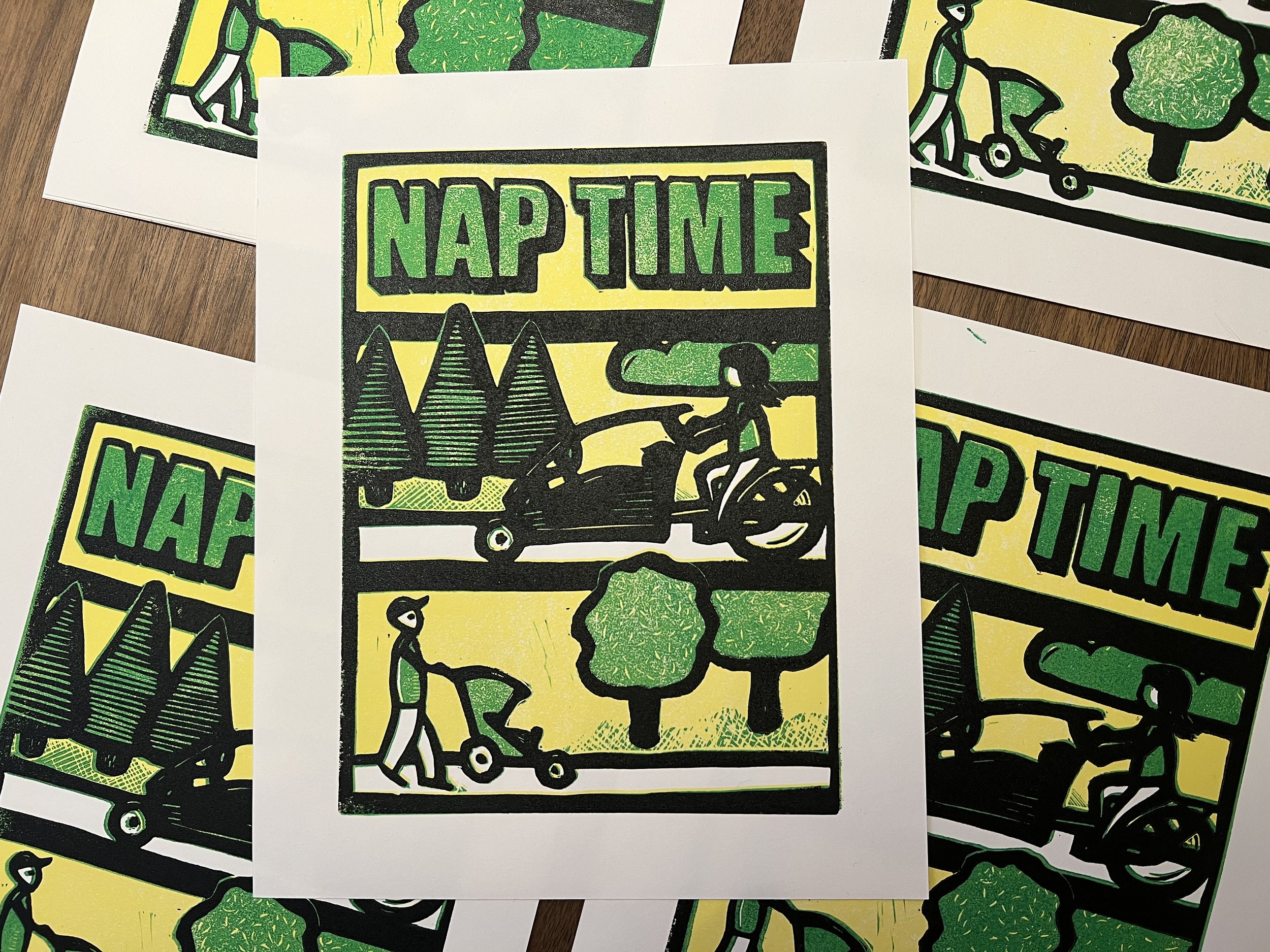 My first three color reduction print. Titled "Nap Time" and displaying me pushing a stroller and my wife riding an Urban Arrow Family cargo bike. The print is black, green, yellow and white.