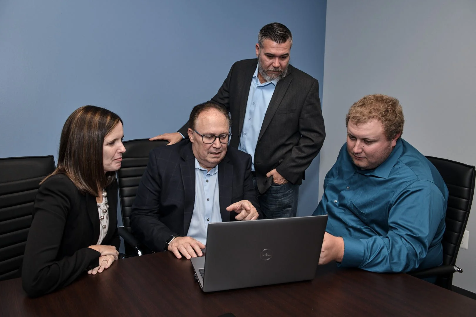Professional accounting firm team in action doing work.  Professionals sitting at a table discussing a clients portfolio.