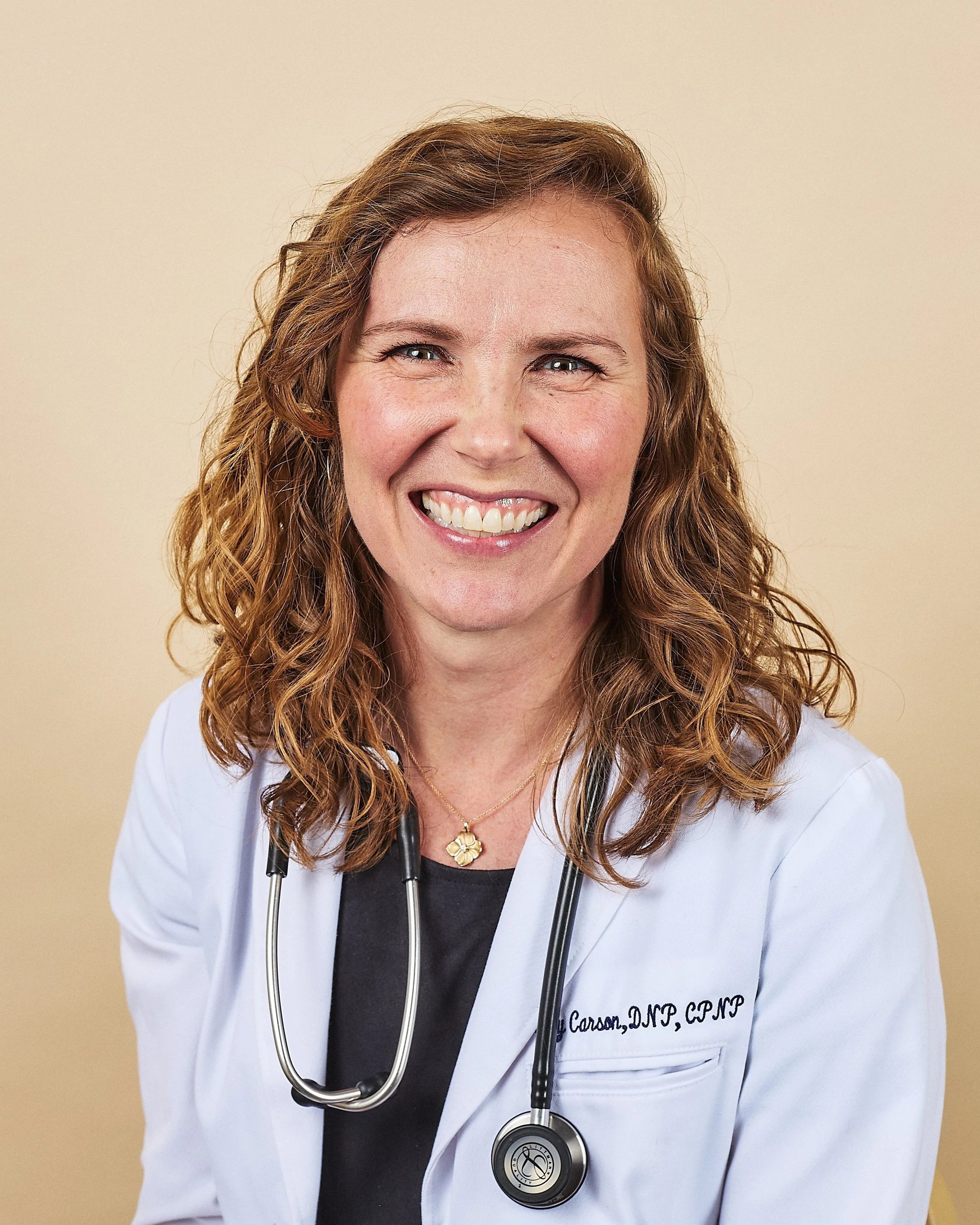 Becky Carson, pediatric nurse practitioner, laughs in a professional portrait