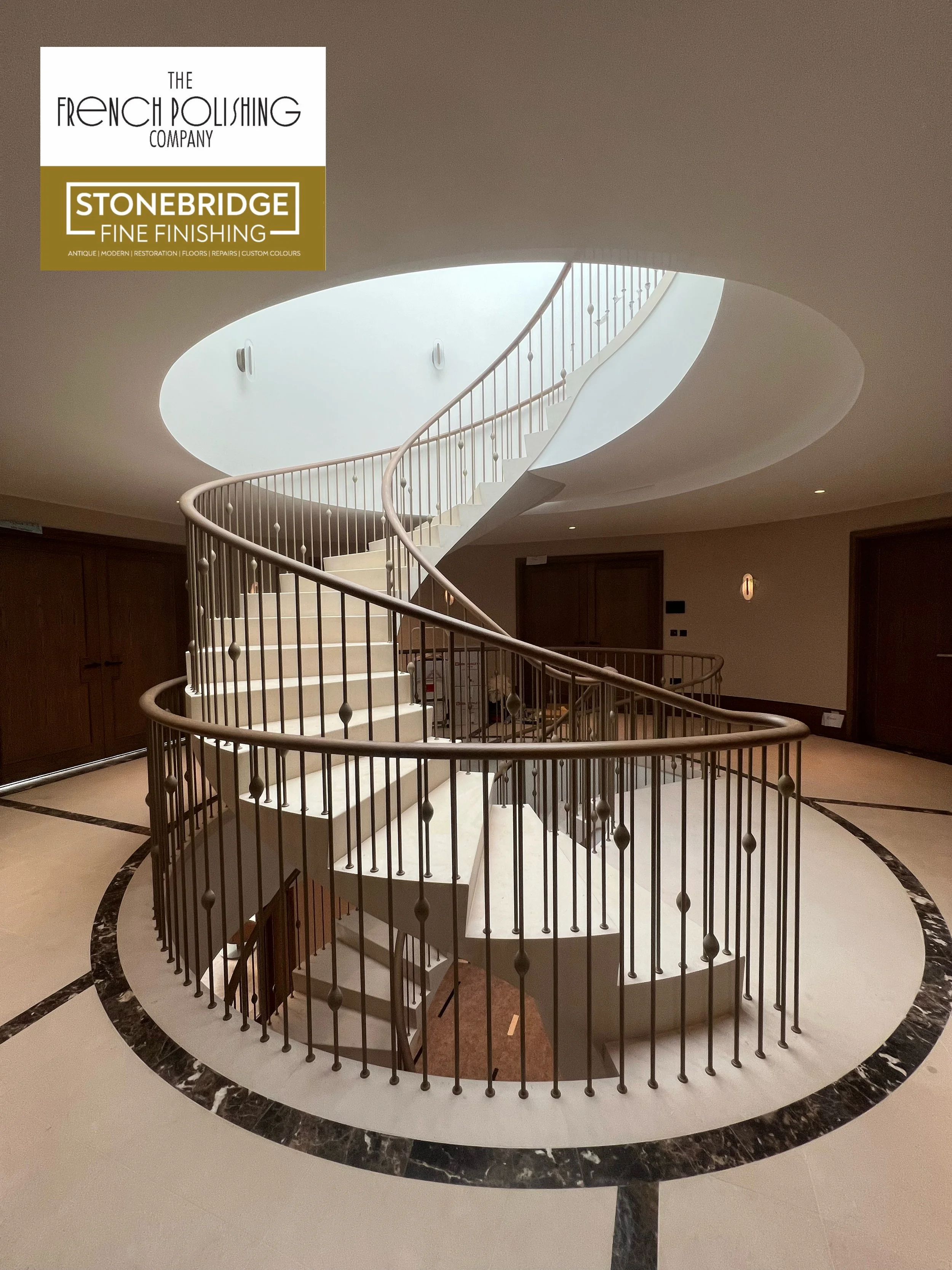 A spiral staircase with a metal railing in a spacious, well-lit interior area.