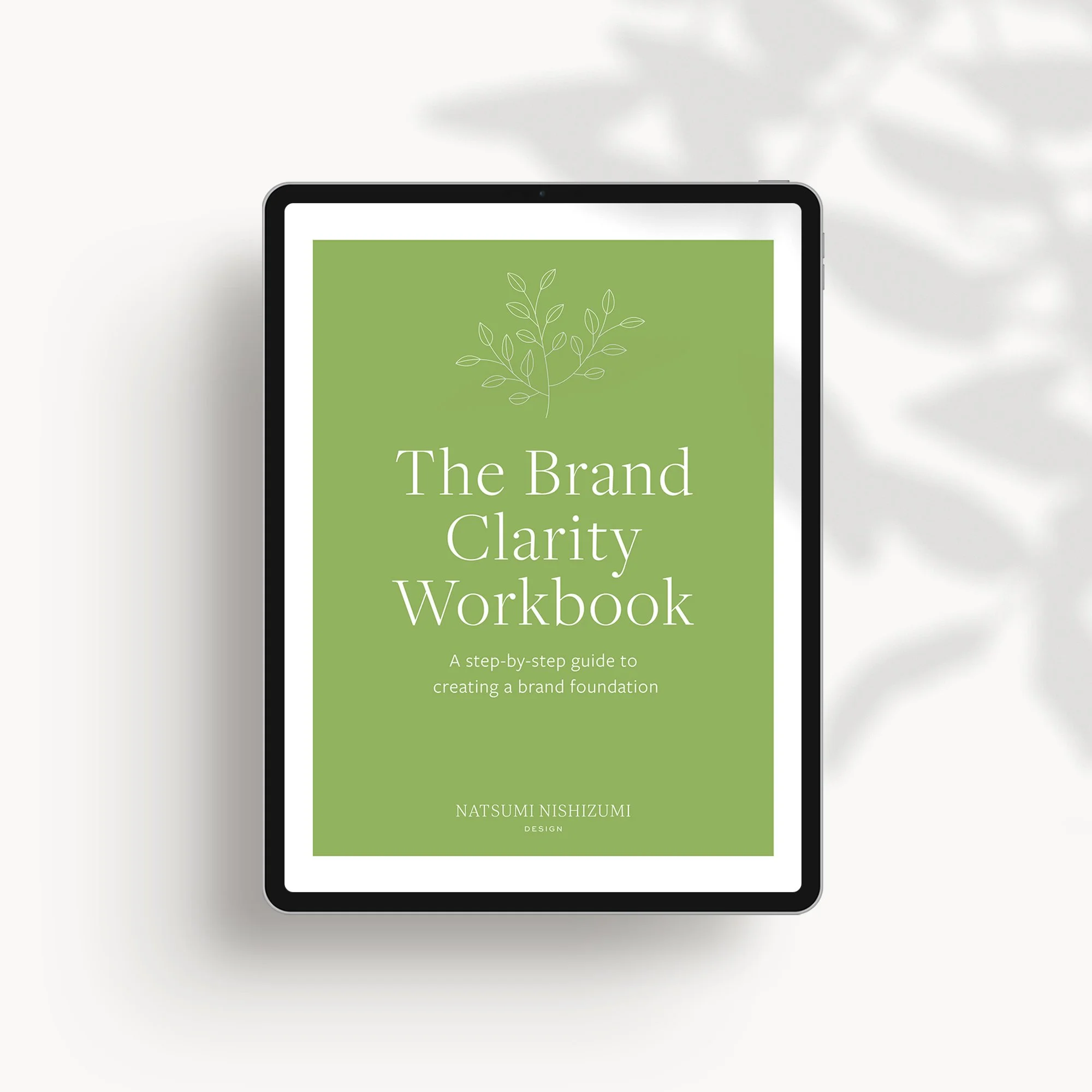 Brand Clarity Workbook cover on tablet with green plant illustration