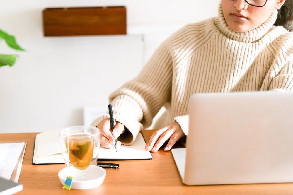Designer working on an annual report layout on a laptop at a desk