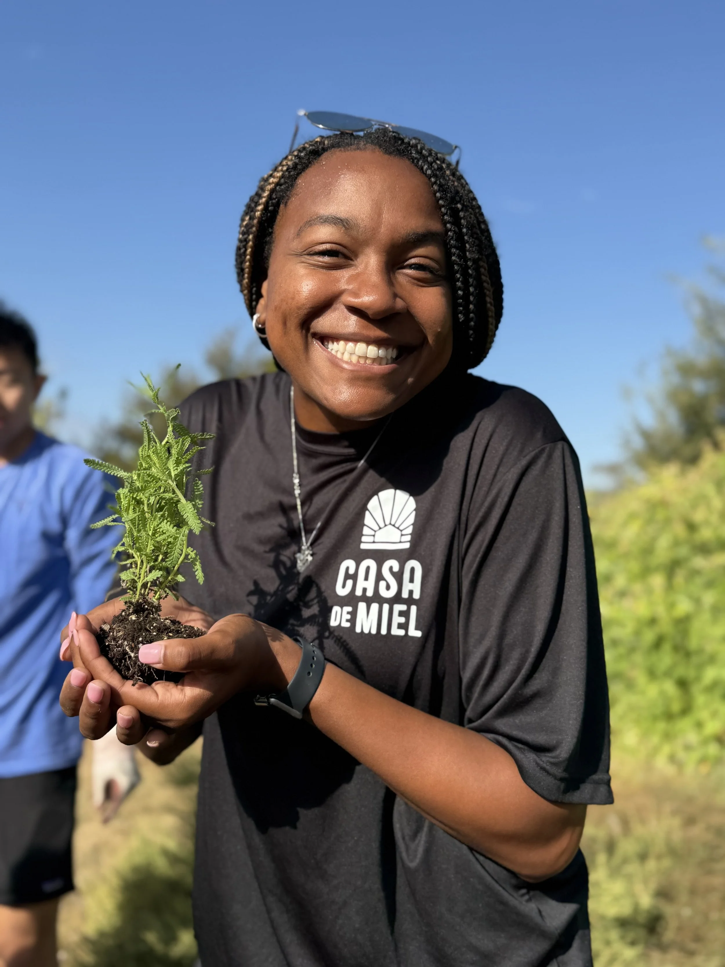 Woman in a Black shirt holding a small plant