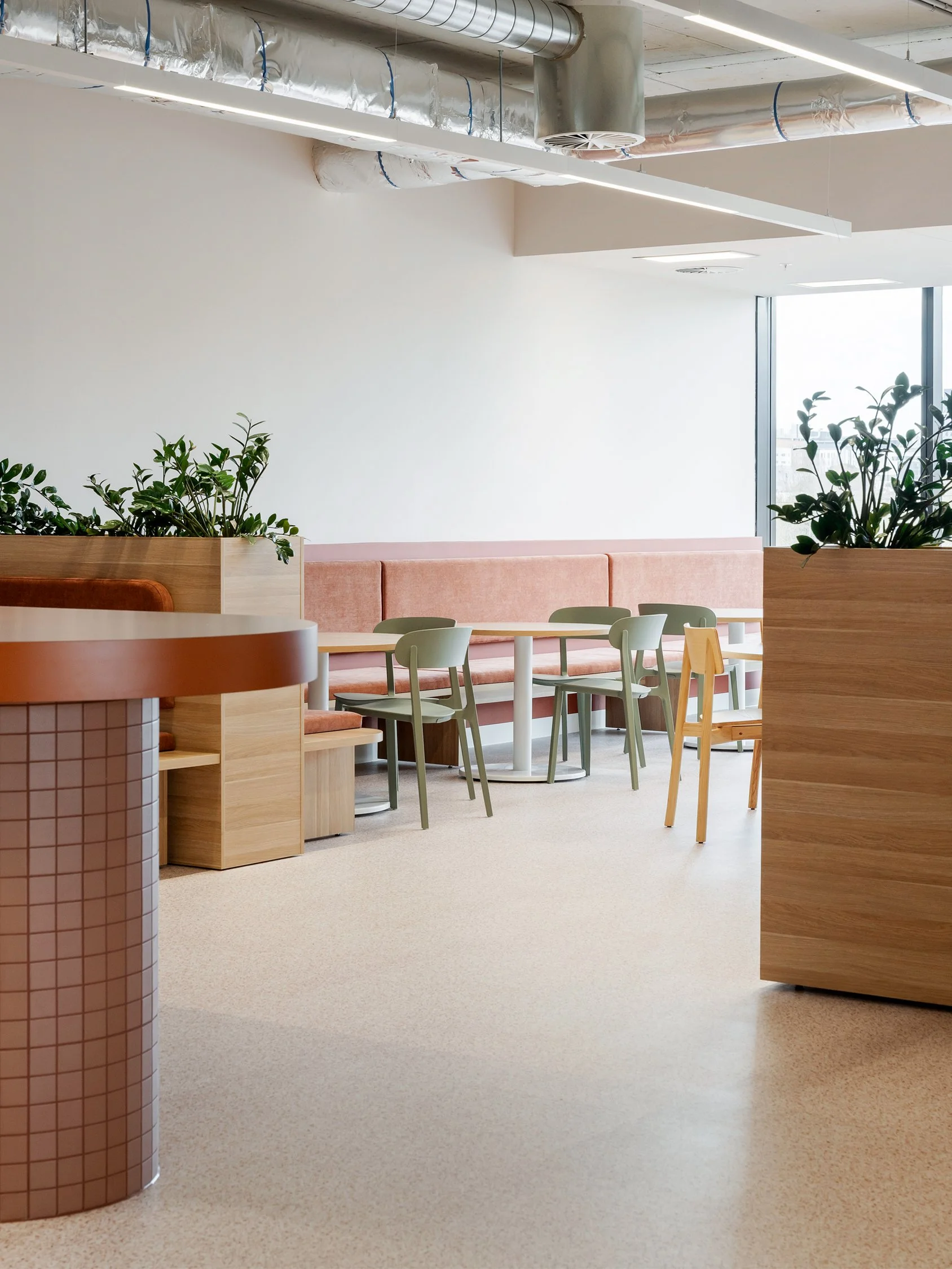 Open workspace corridor showing built-in wooden storage units and informal seating areas.