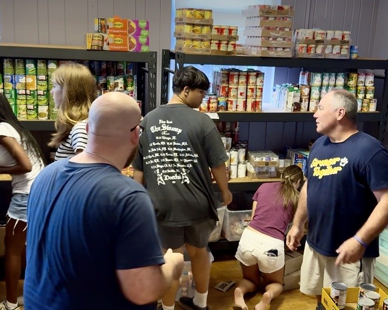 Stocking food shelves at Triune Mercy Center
