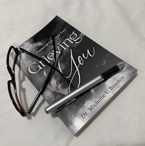 Learn about book titled "Grieving You" by Dr. Michelle V. Boodoo and discover resources for suicide prevention, depression support, emotional wellness, and mental health education through In Her Name.