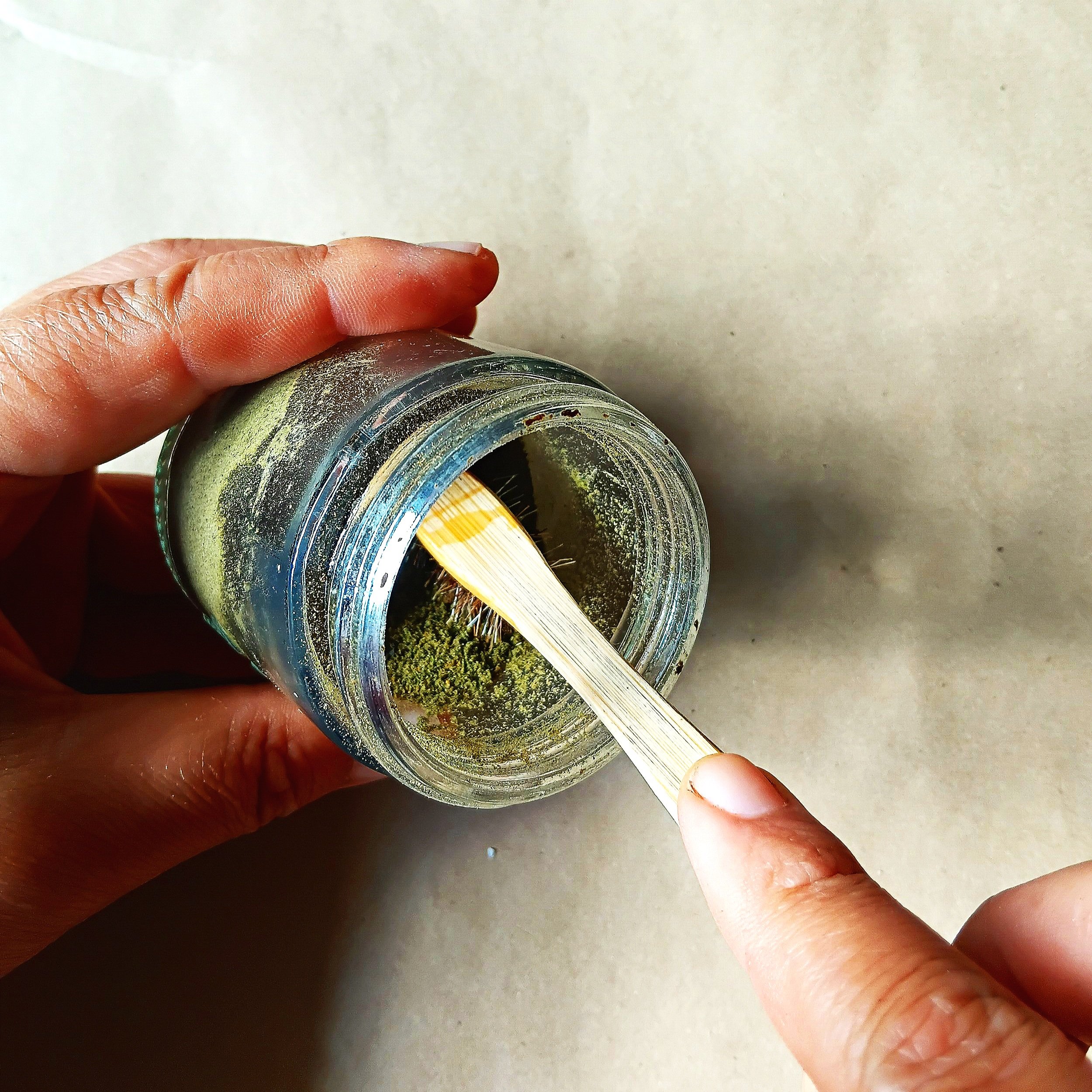 Wet your toothbrush bristle and dip into the tooth powder to pick up some of the tooth powder.