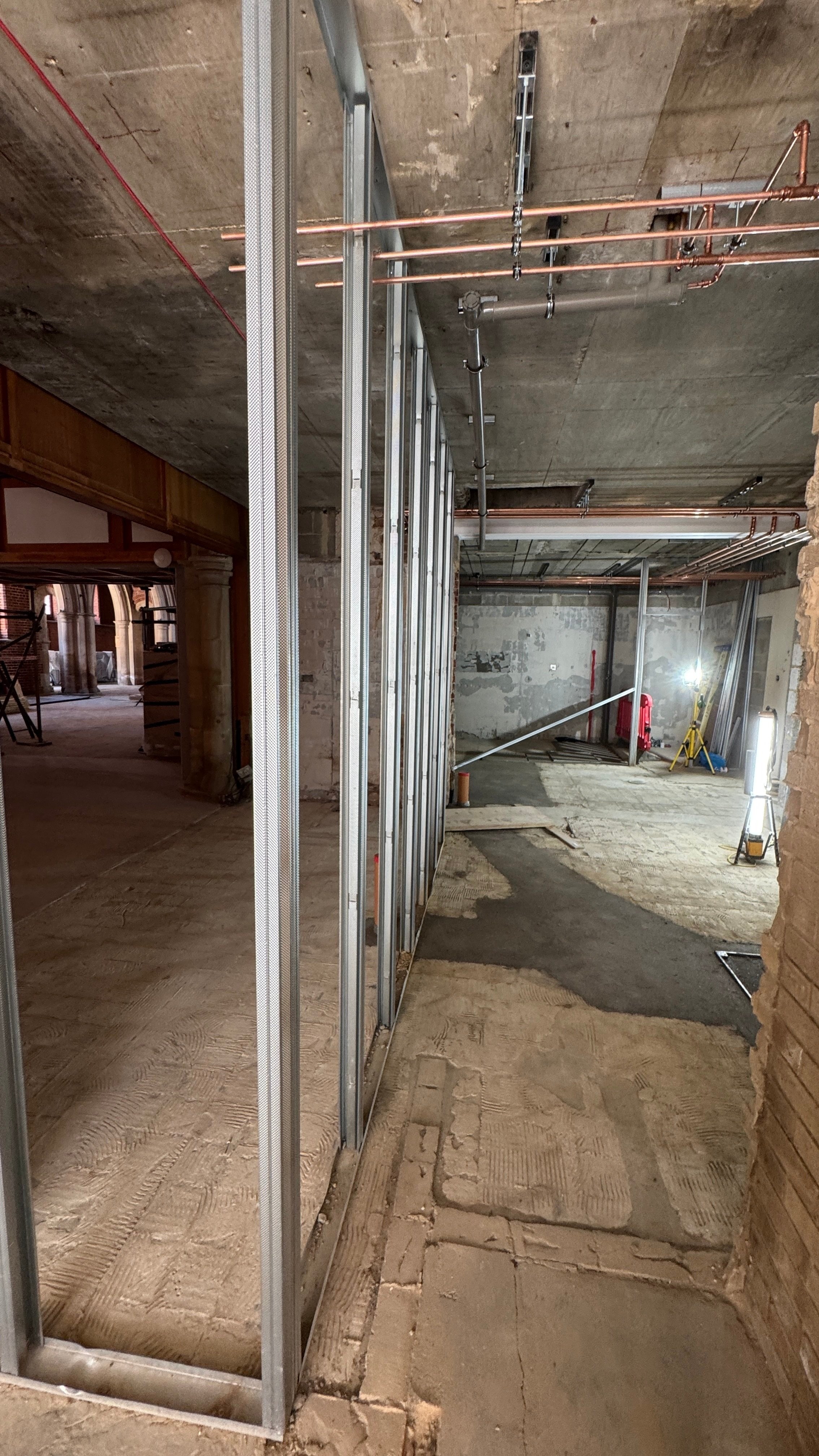 The expanded kitchen space from the side door; new drainage in the floor