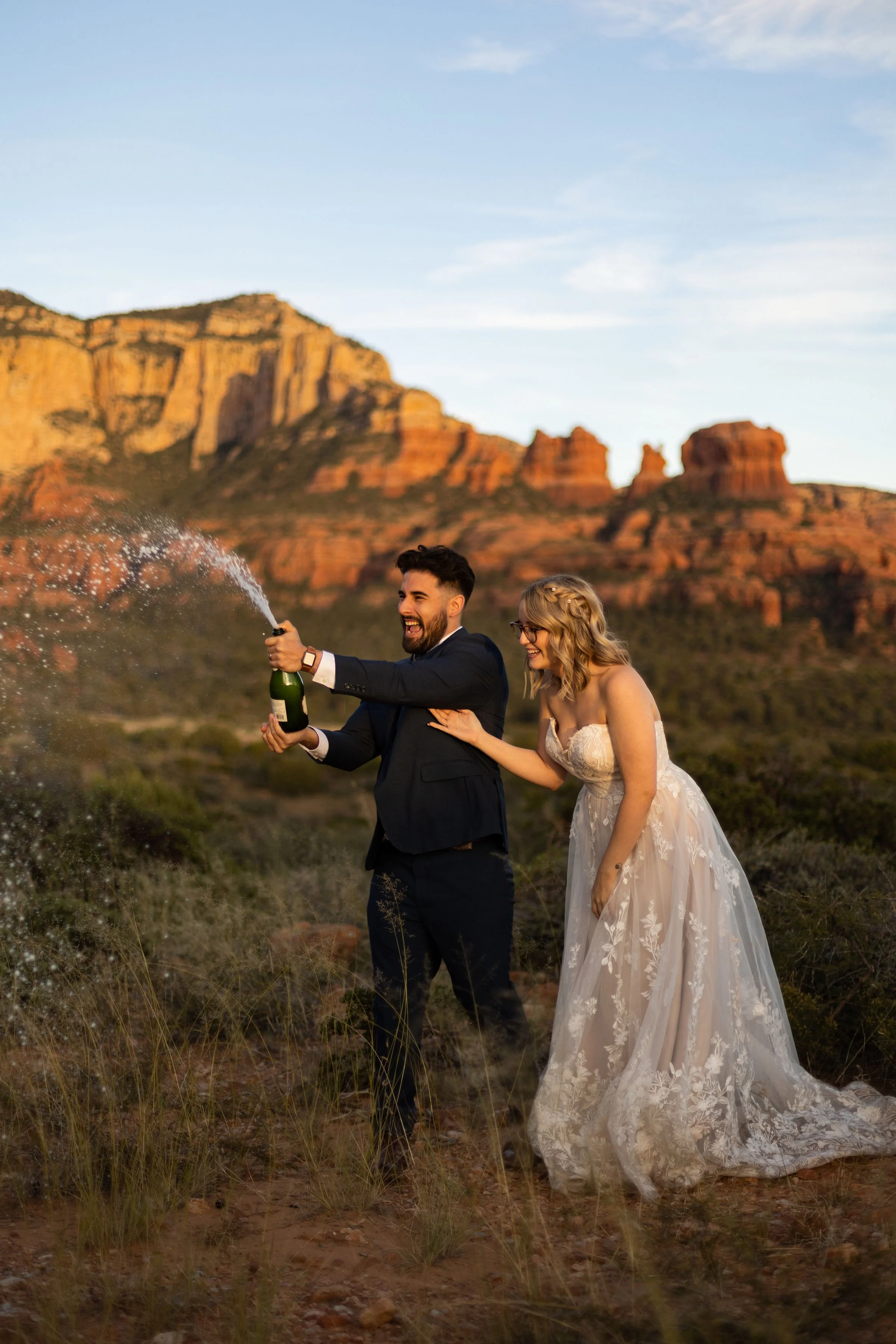 couple opening champagne after their Sedona wedding by Sedona elopement photographer Nick Patton