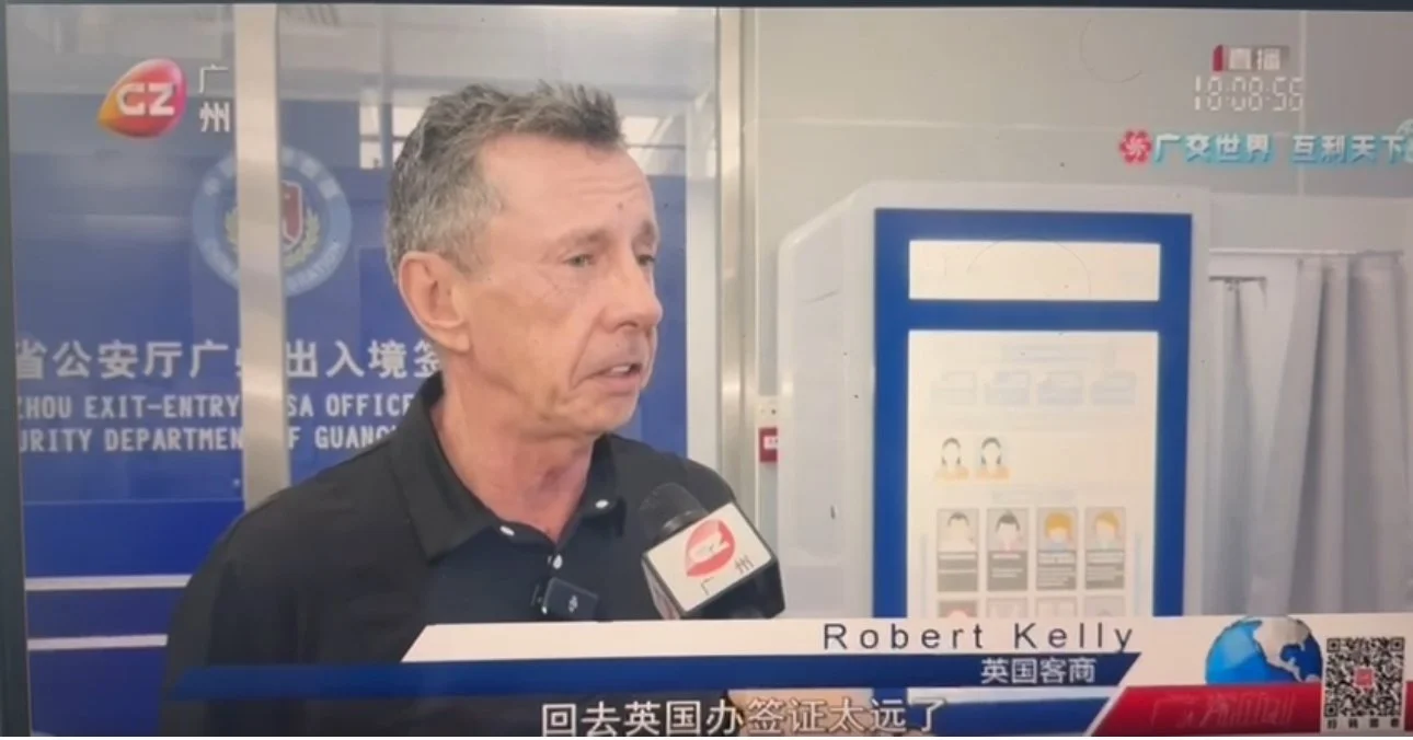 A man being interviewed by a news channel at an airport, with a sign for exit and entry security in the background, and Chinese characters on the screen.