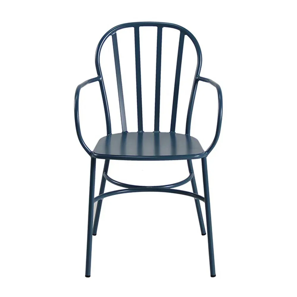 Empty café table with a window view, set with plates, salt and pepper shakers, and utensils in a holder.