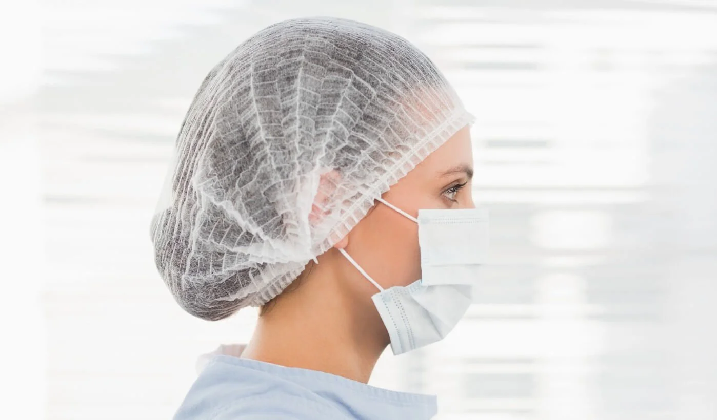 Side view of person wearing a white disposable hairnet from Amabilia Core