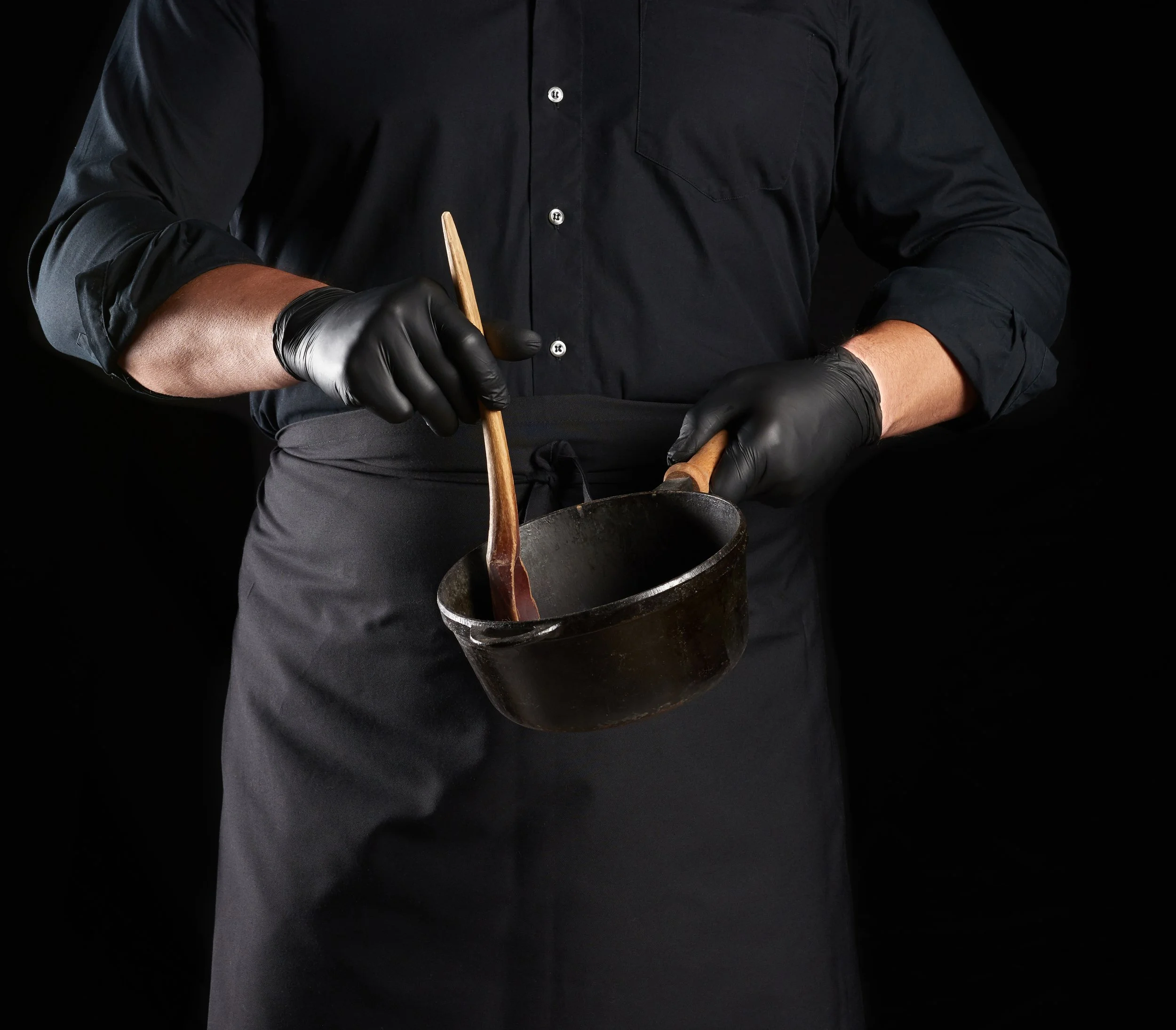 Black AMABILIA® PRO nitrile gloves are used in a professional environment, shown on a person at work.