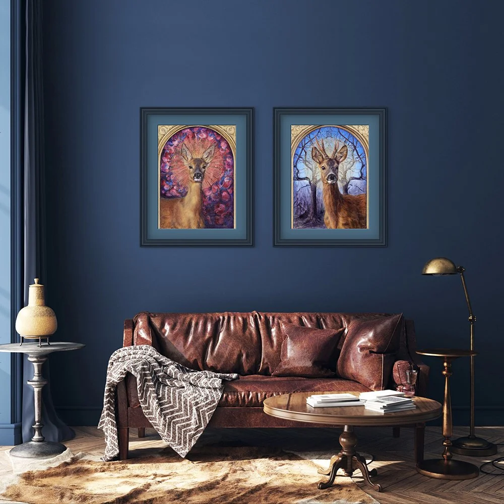 Framed giclee print is of a male roe deer with a sunburst halo against a background of mirrored winter trees - hanging on a teal wall in a cosy sitting room. Print available to buy from Karina Tarin.