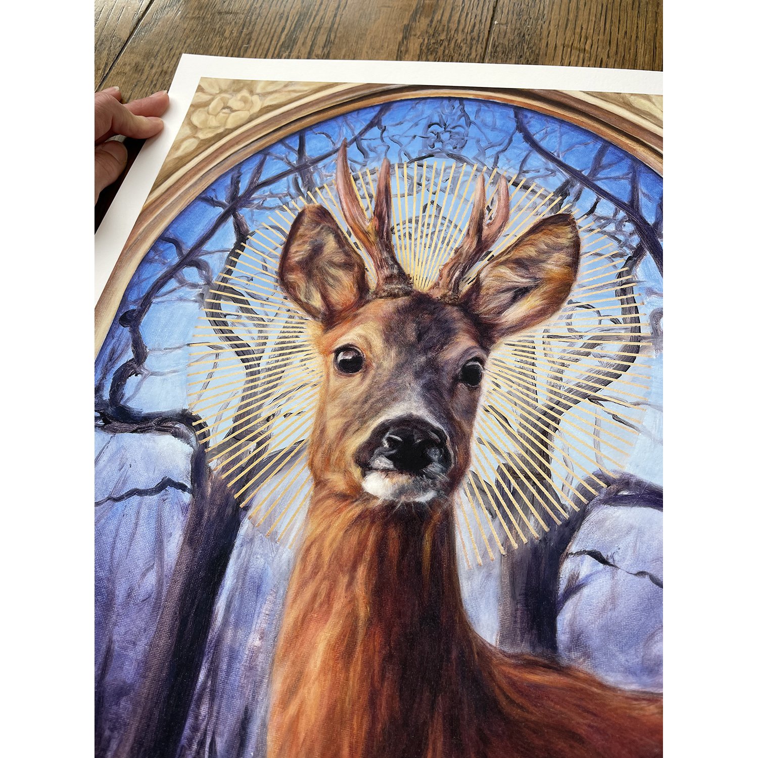 A high quality giclee print of a handsome roe deer buck with a halo against a background of winter trees. Art print available to purchase. By imaginative realism artist Karina Tarin.