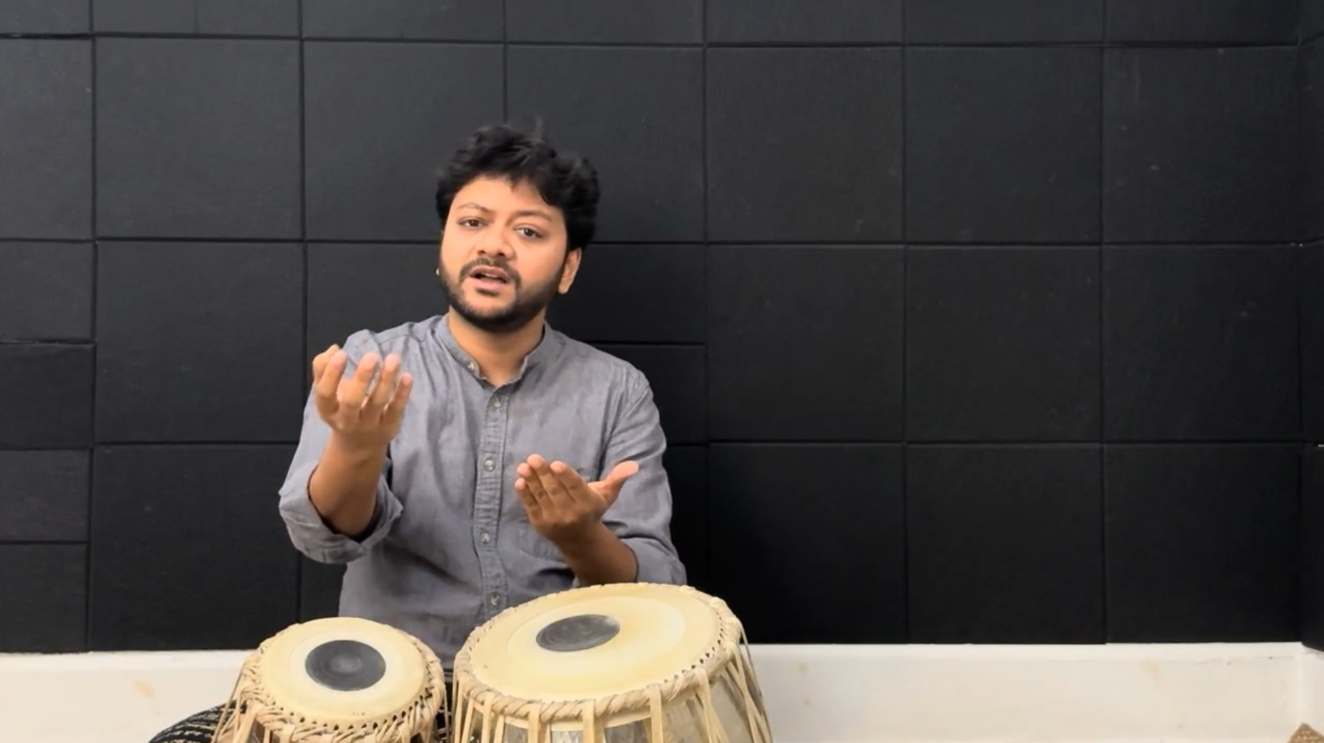 Mir demonstrating the tin tal rhythm with hand gestures.