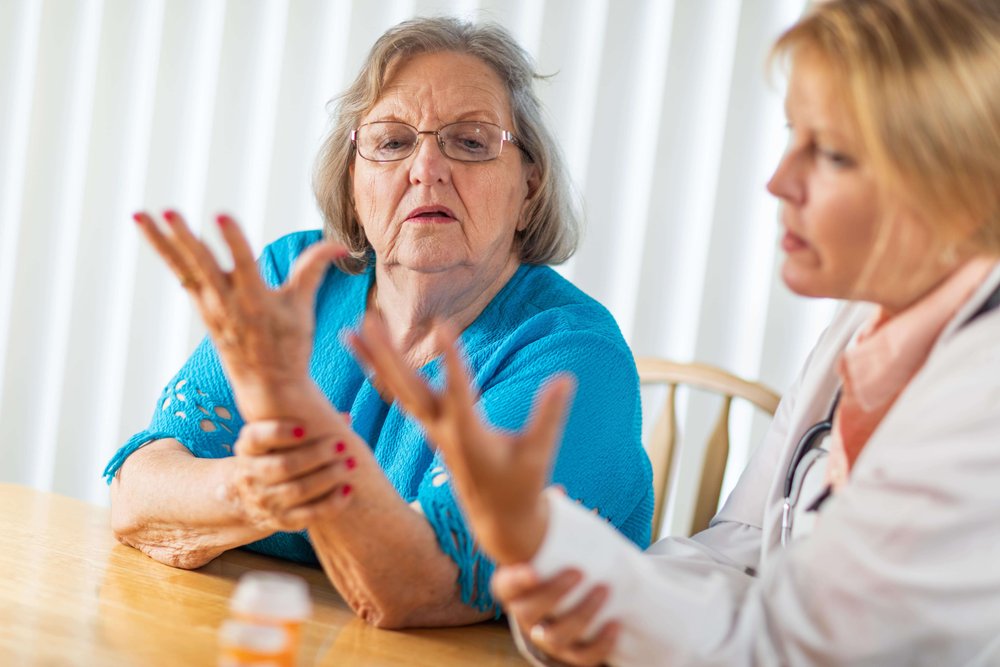 Elderly woman and a nurse doing hand exercises