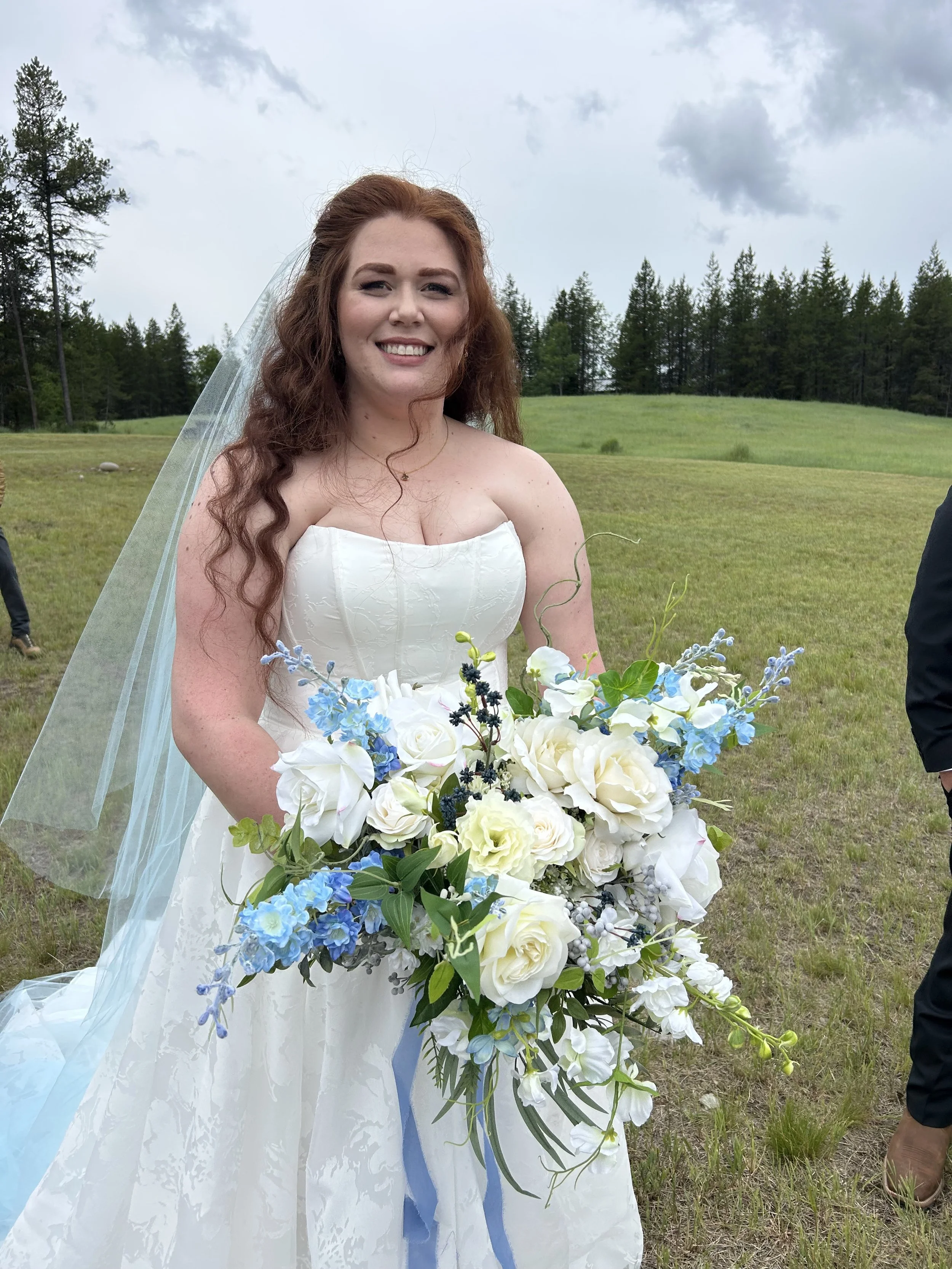 Bride holding. a garden-style blue and white silk wedding bouquet