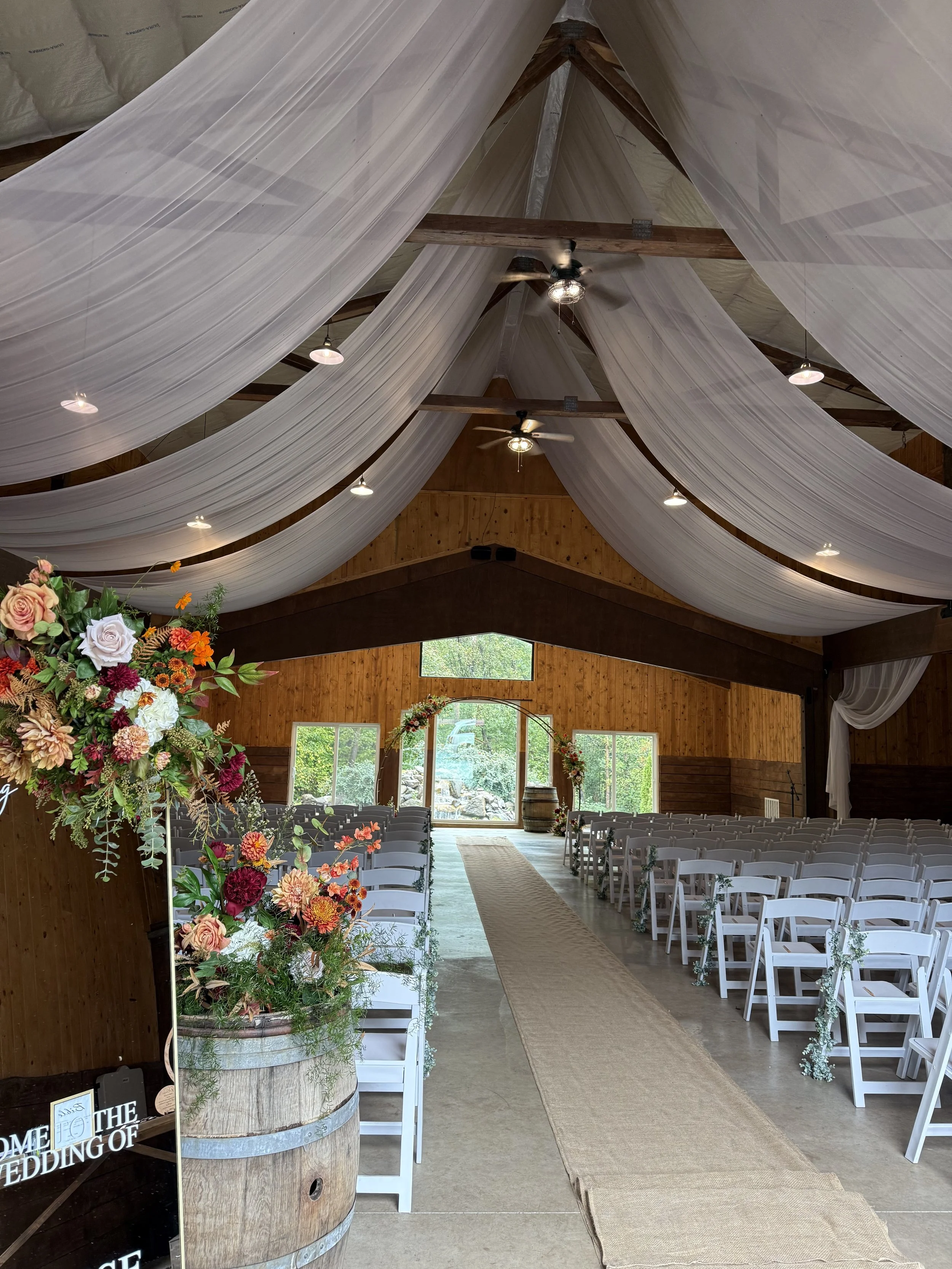 Indoor wedding ceremony space with colorful garden-style silk floral arrangements