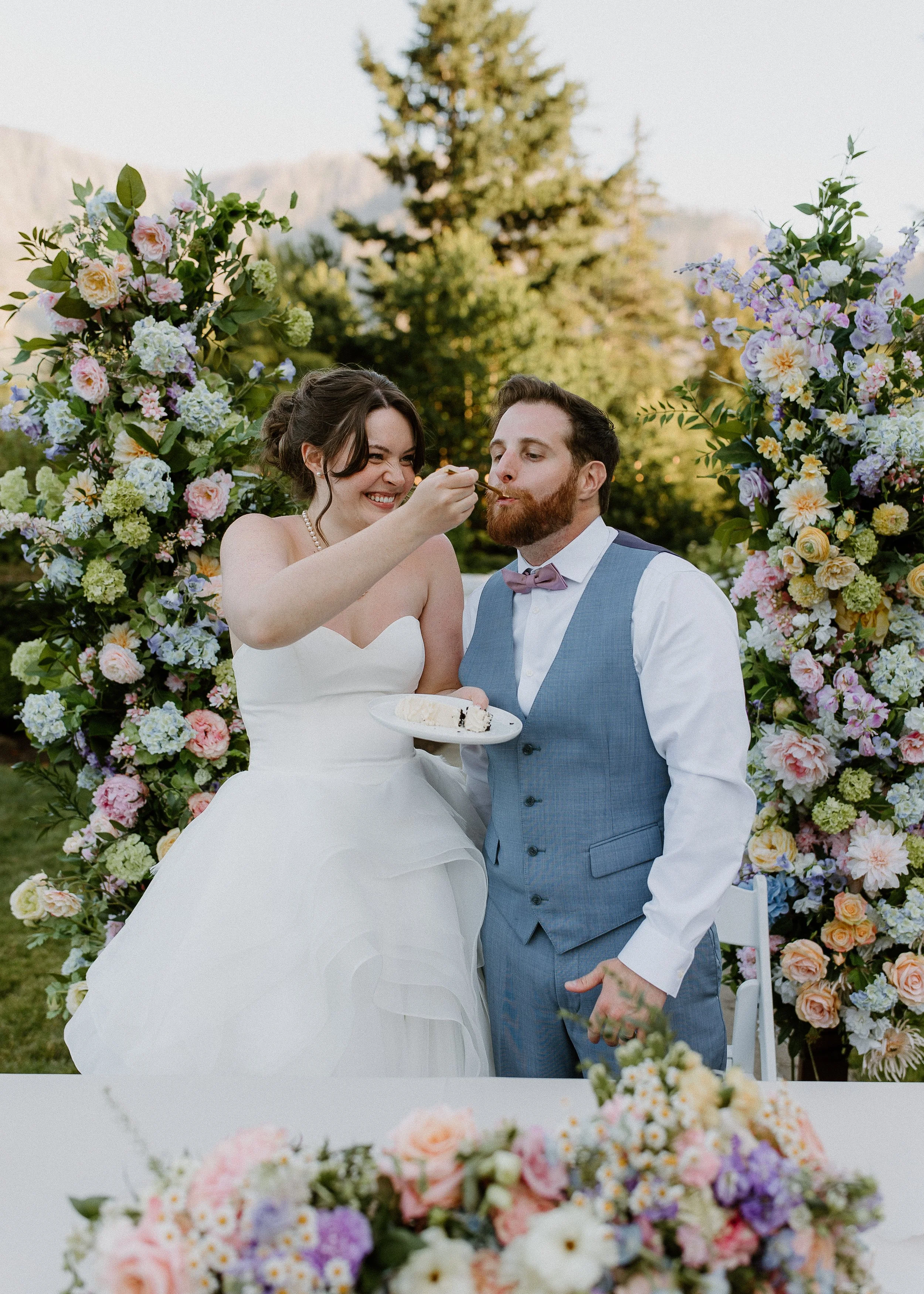 Bride and groom celebrating in front of silk floral wedding pillars