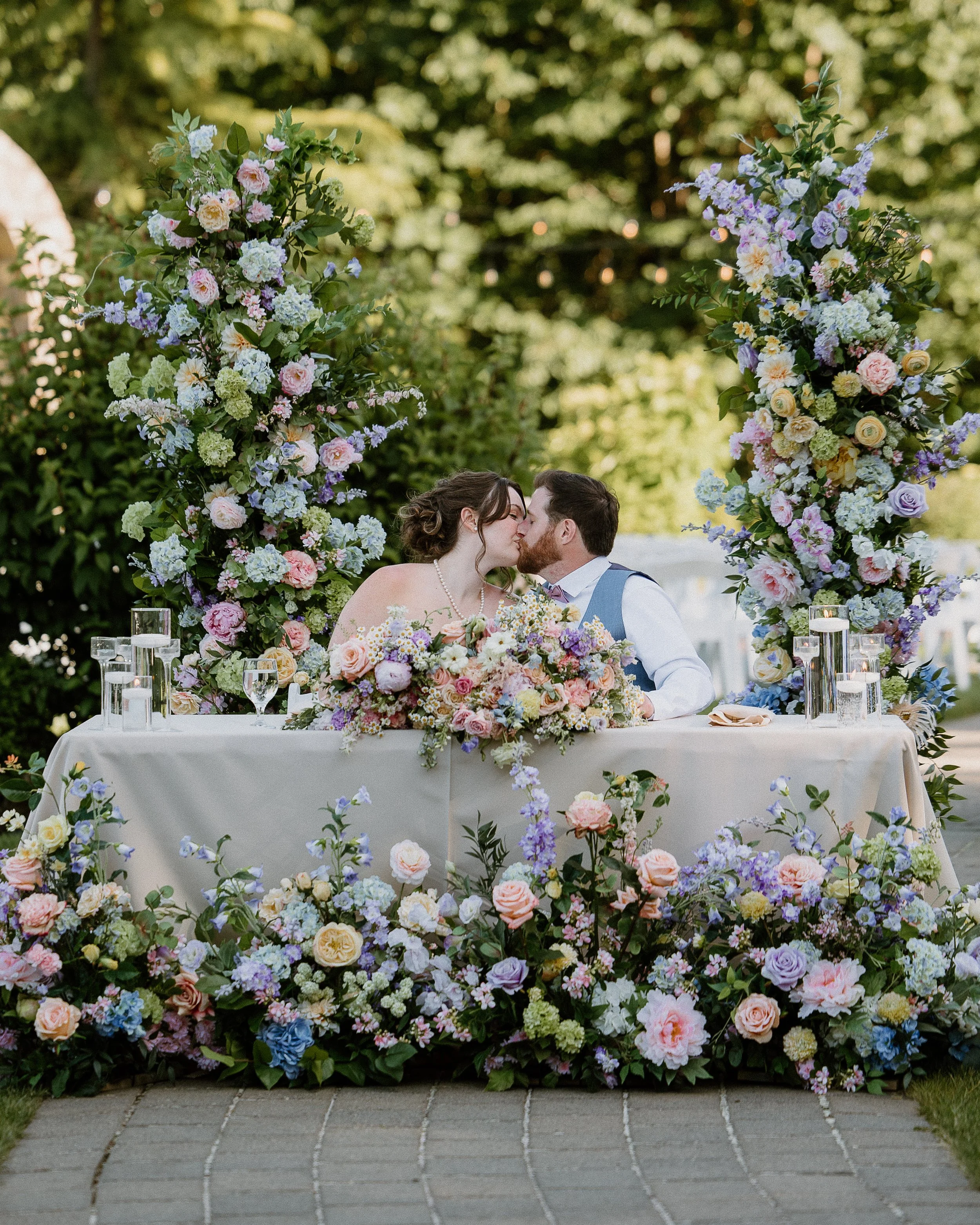 Sweetheart table framed by luxury silk floral wedding pillars