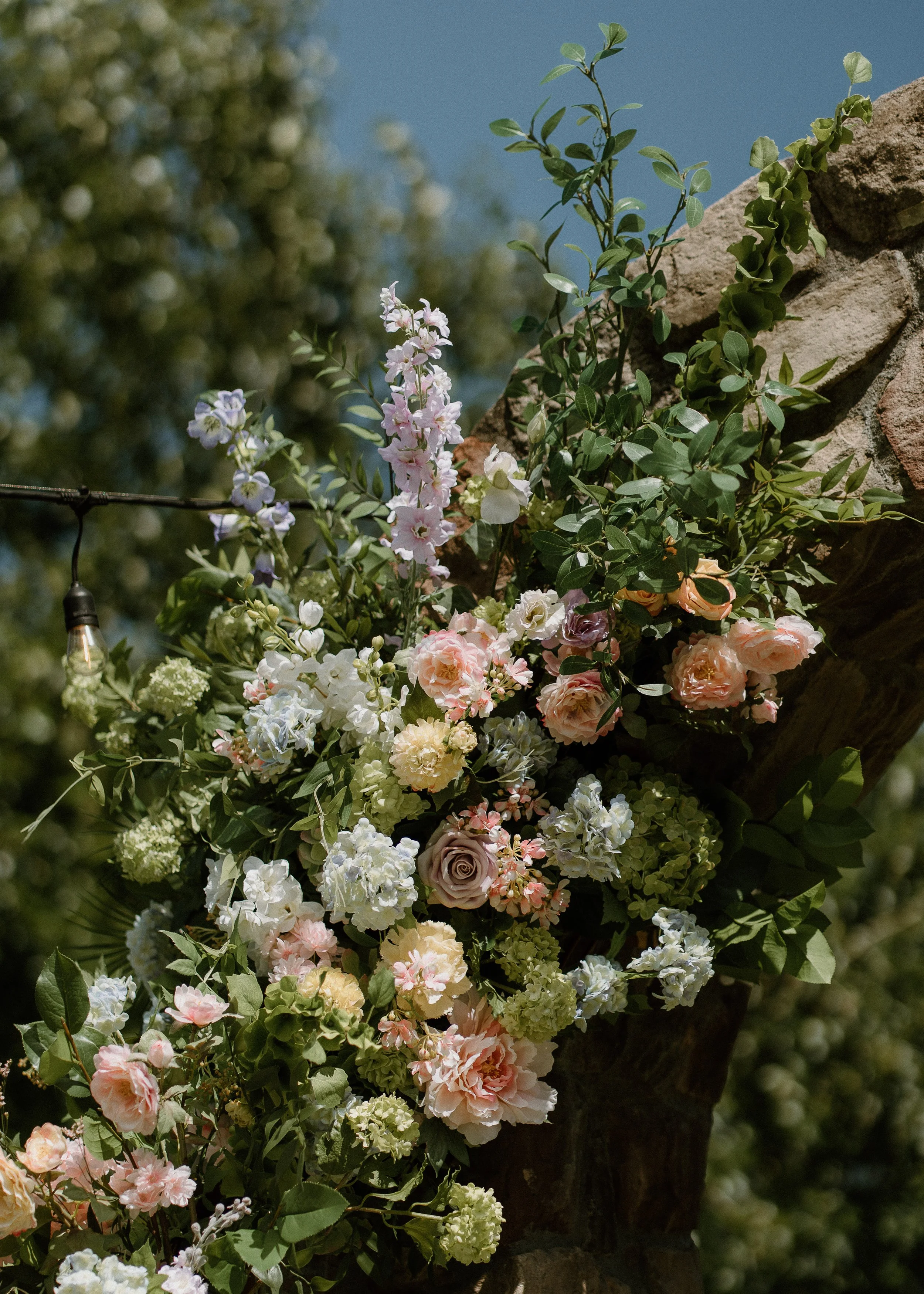 Close-up of garden-style silk flowers on a wedding ceremony arch