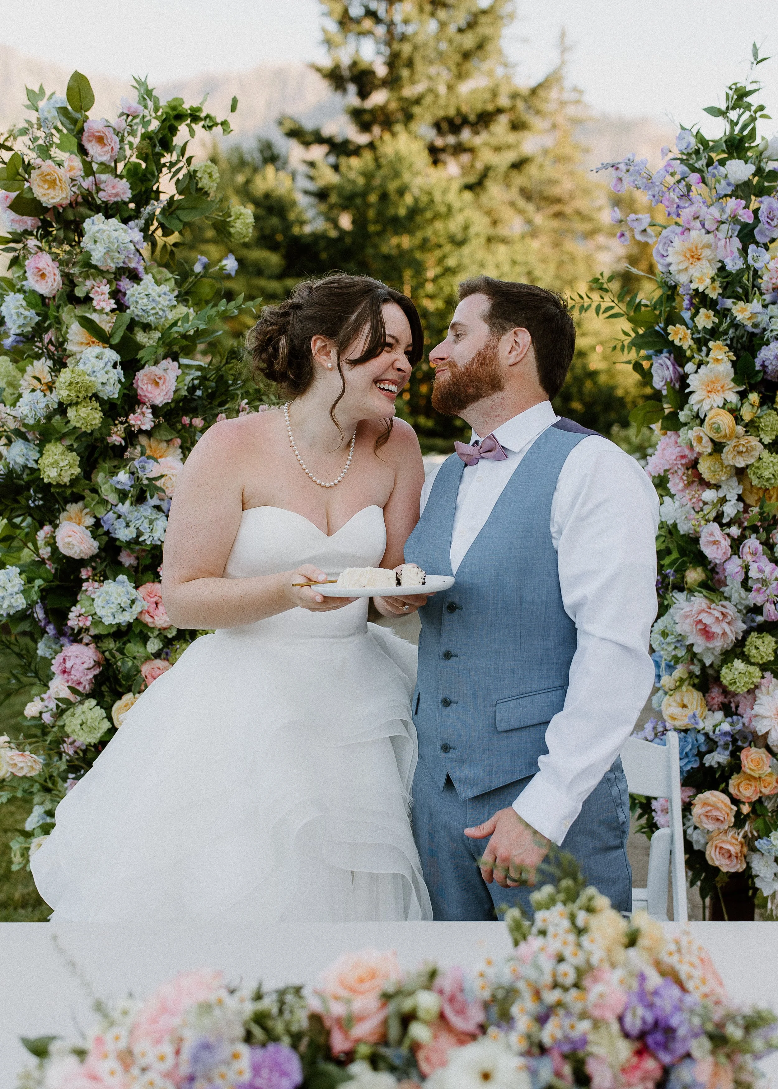 Bride and groom in front of luxury silk floral wedding pillars