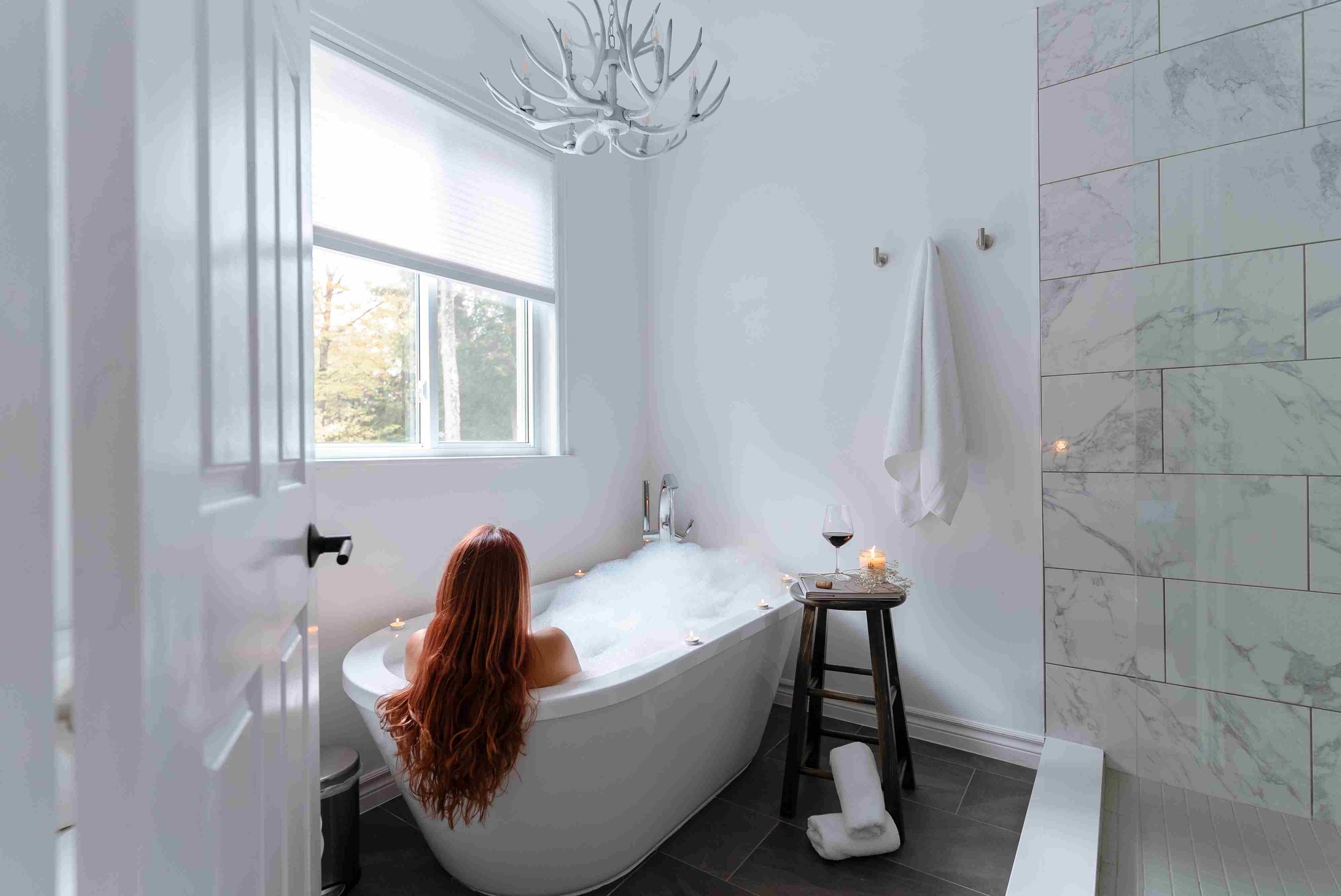 White Antlers chandelier over soaker tub at H2H Cottage on Bitter Lake in Haliburton Highlands