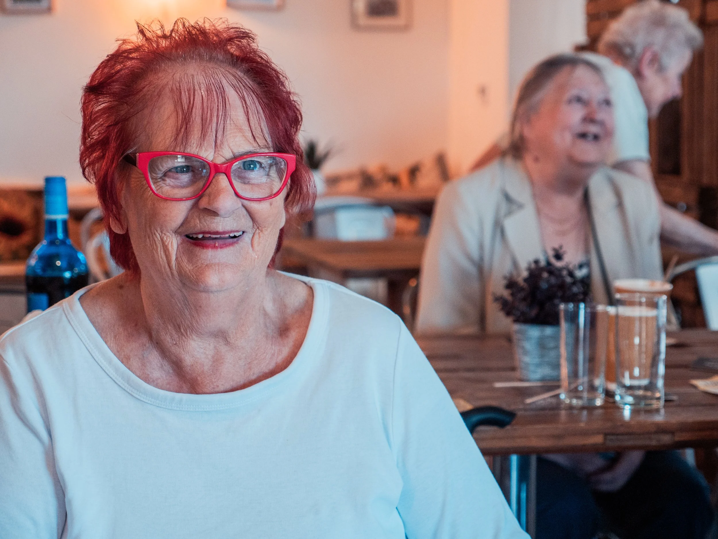Older woman with red hair and red glasses