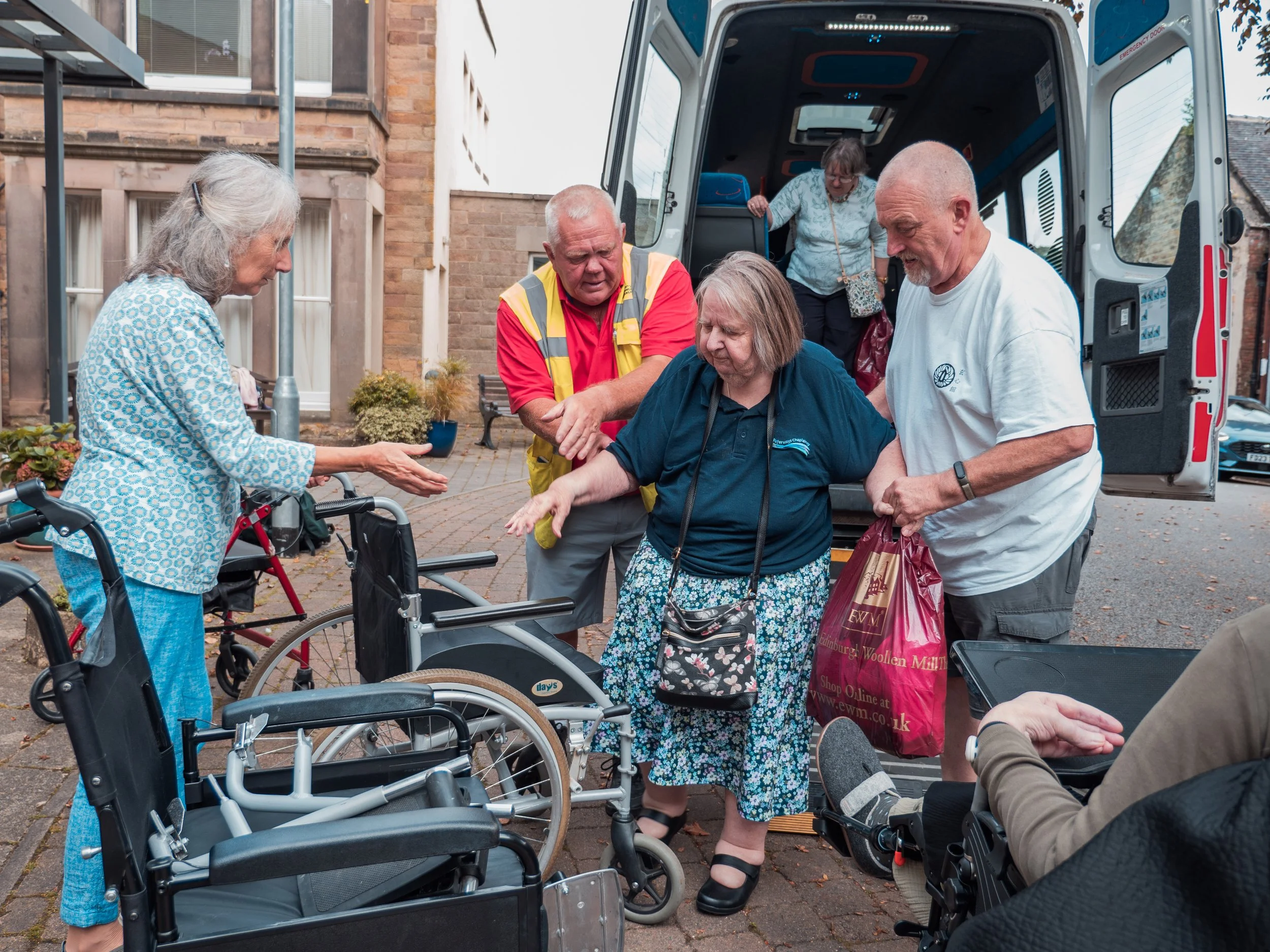 Older woman being helped out of community bus