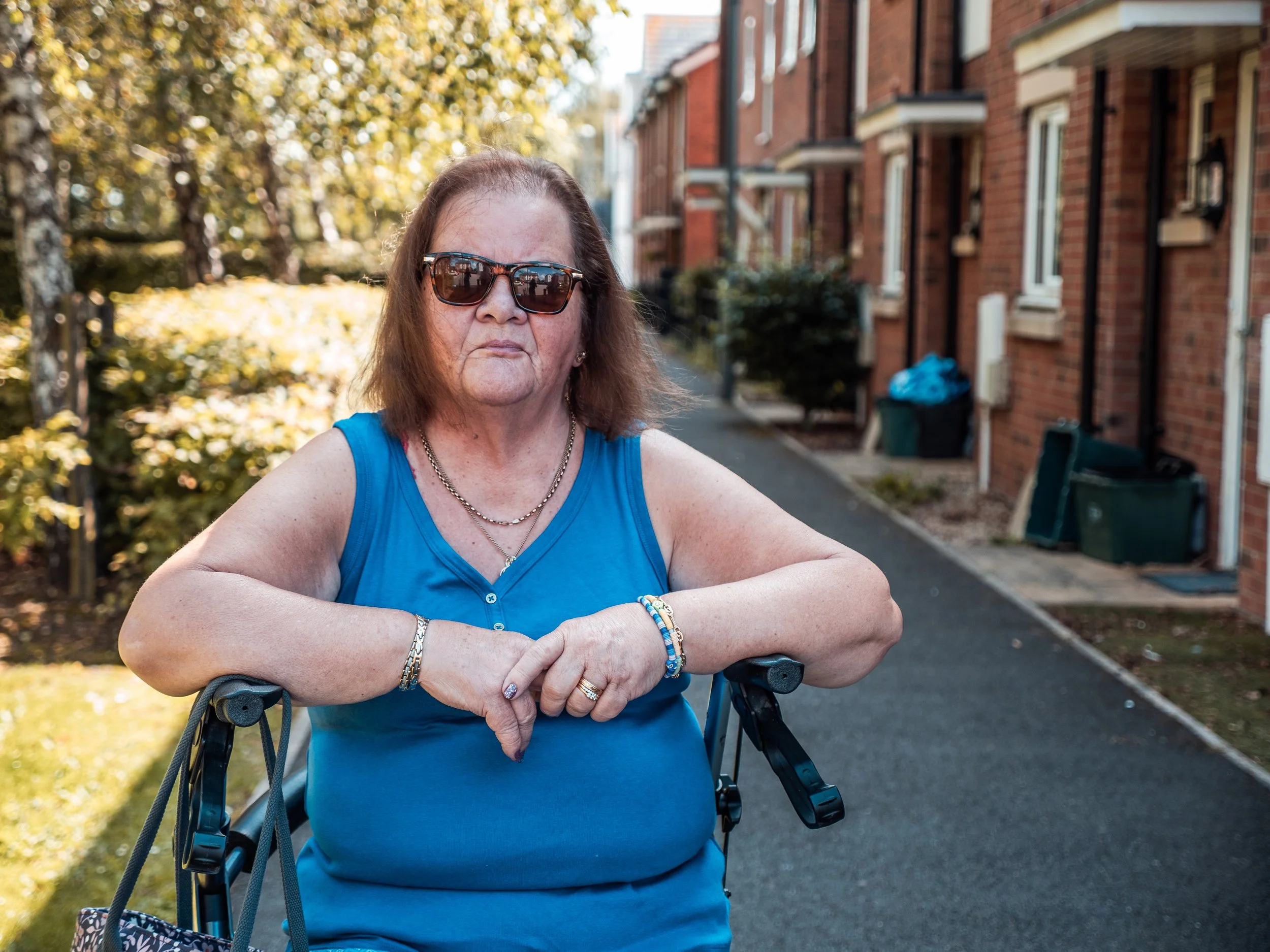 Woman with sunglasses sitting on her walker