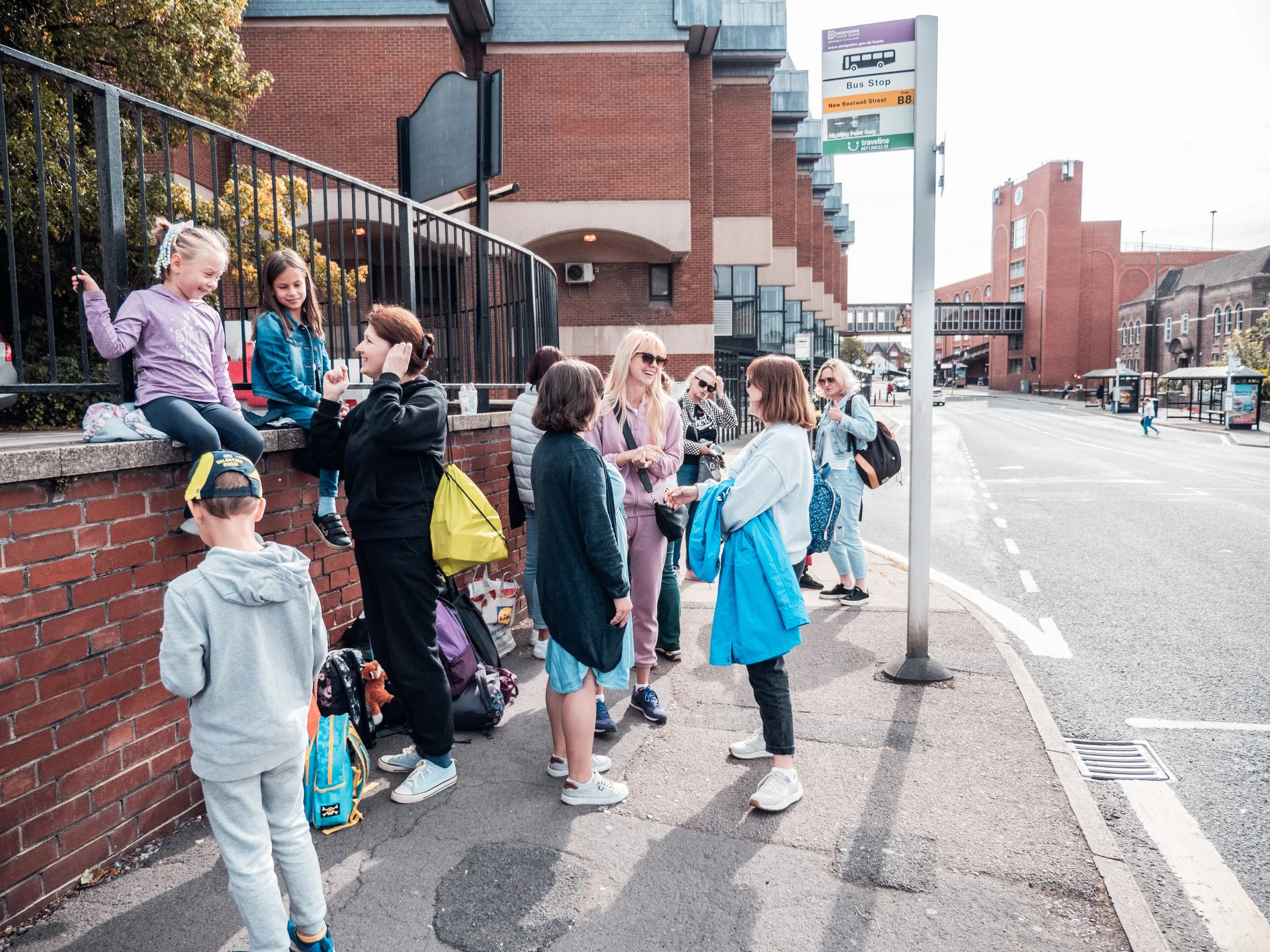 Group of women and kids at bus stop