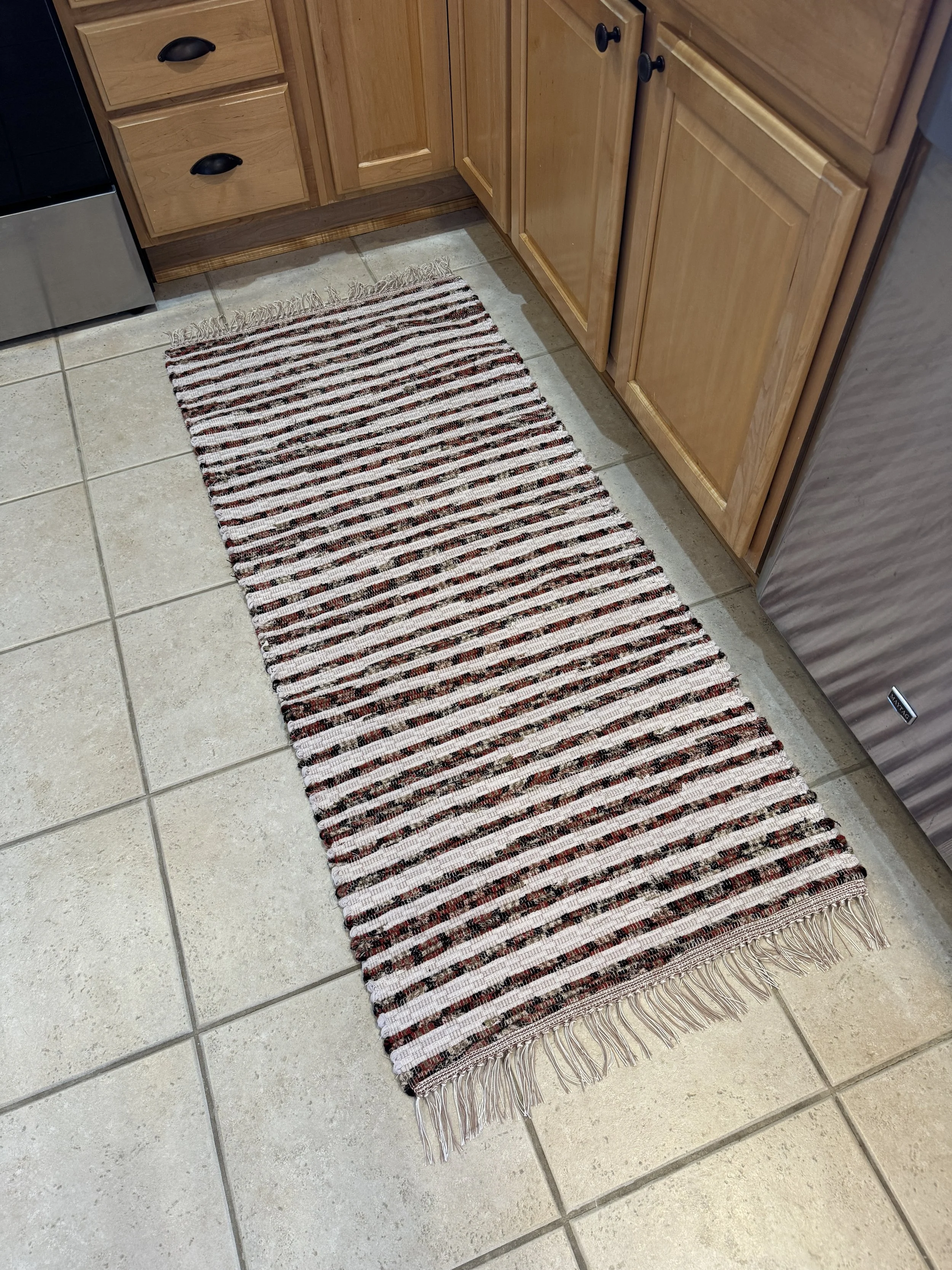Handwoven rust and cream rag rug displayed in kitchen showing pattern
